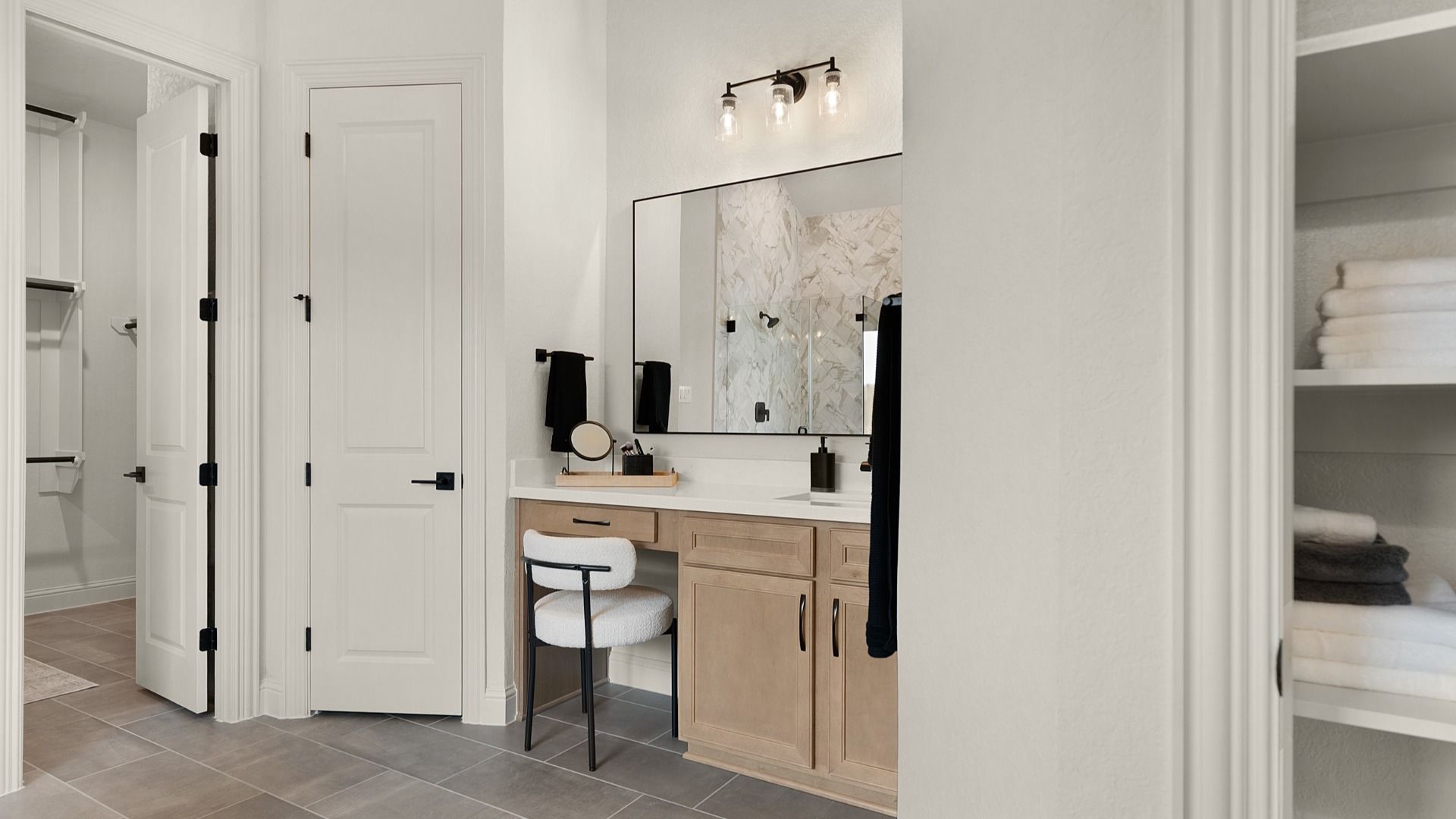 Owner’s bathroom features a true vanity detail with space for a chair, combining function and elegance.