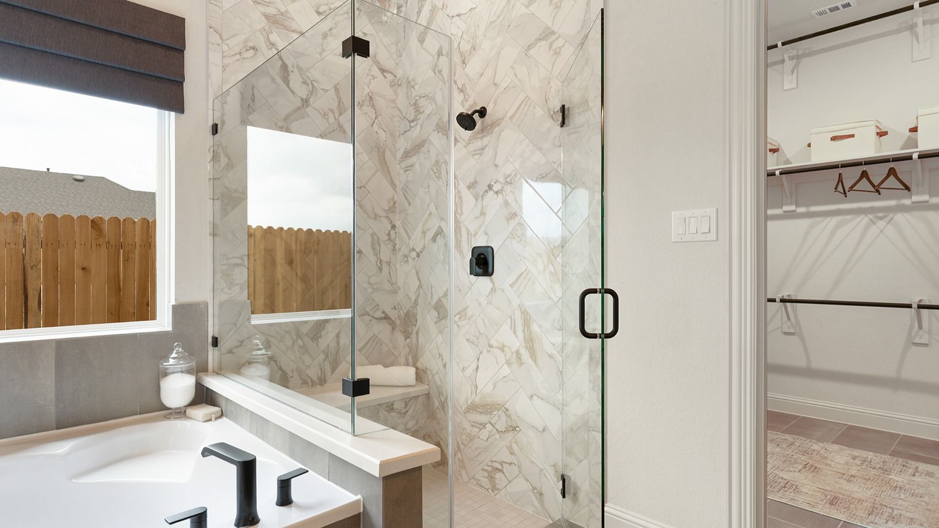 Hand-laid ceramic tile shower with frameless glass and black hardware for a sleek, modern finish.