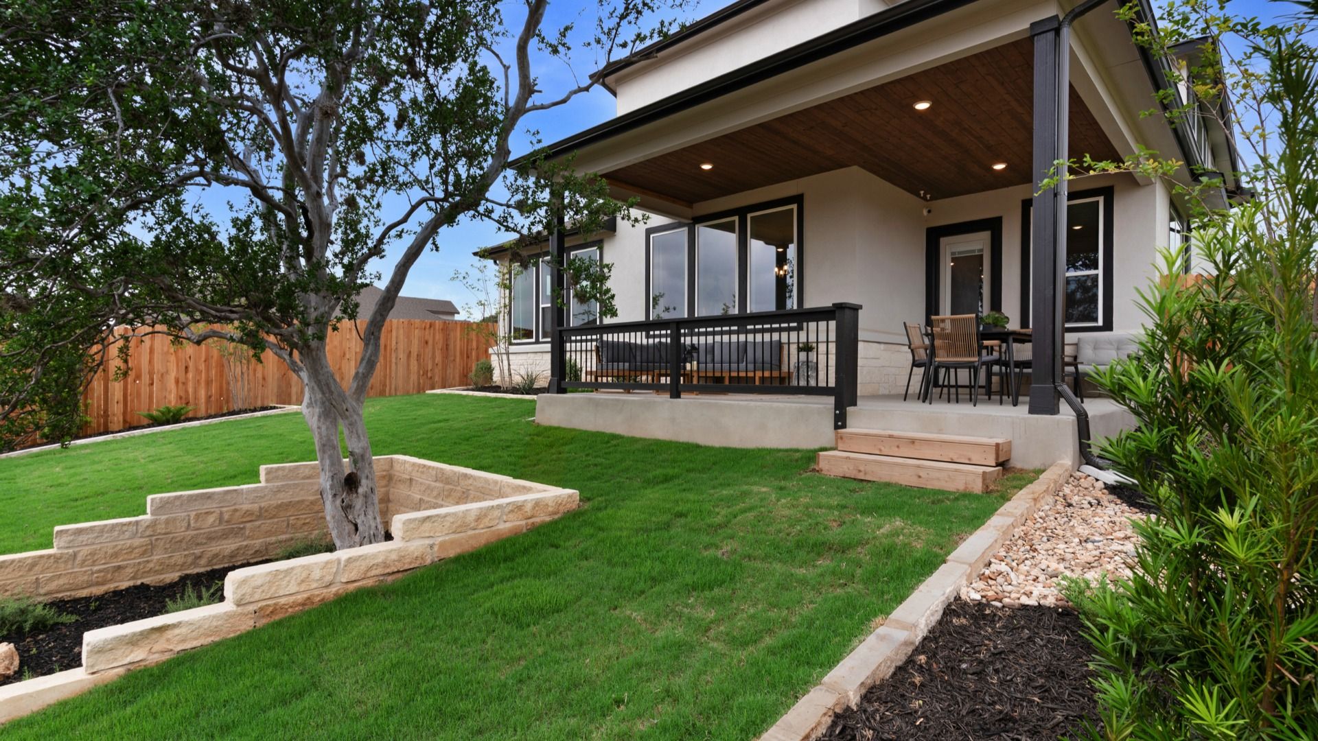 Inviting backyard with large covered patio and refined landscaping details.