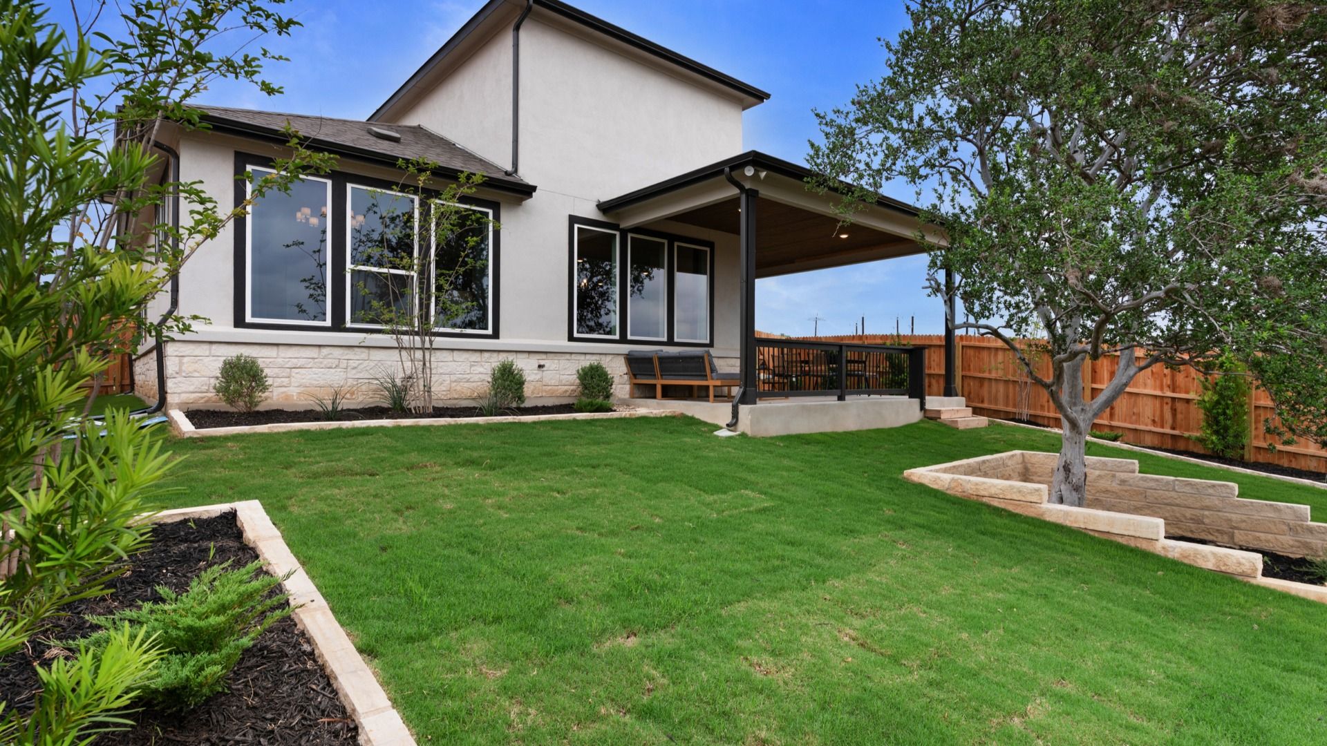 Inviting backyard with large covered patio and refined landscaping details.
