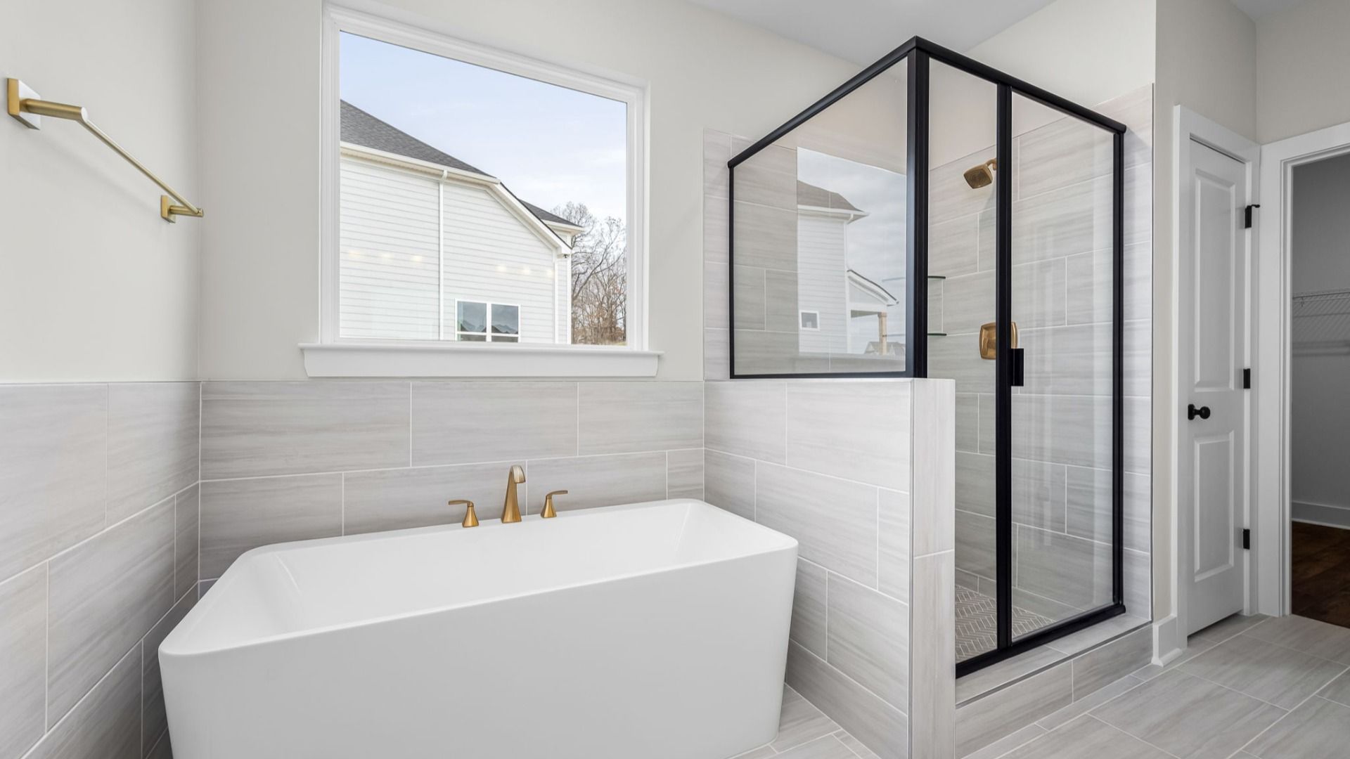 Beautiful primary bathroom with tub and glass enclosed shower