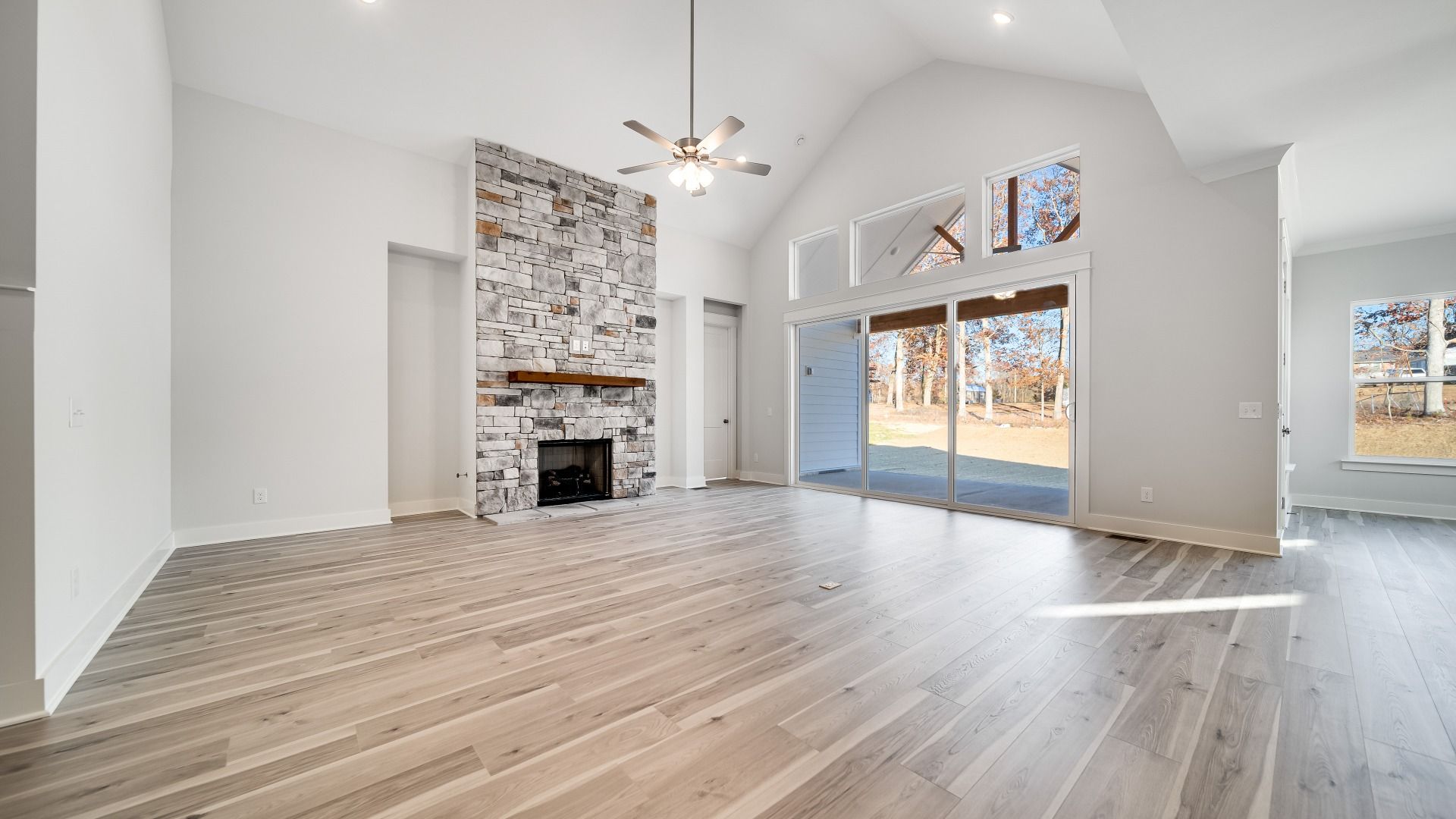 Gathering room with fireplace, high ceilings, and bright natural light through windows