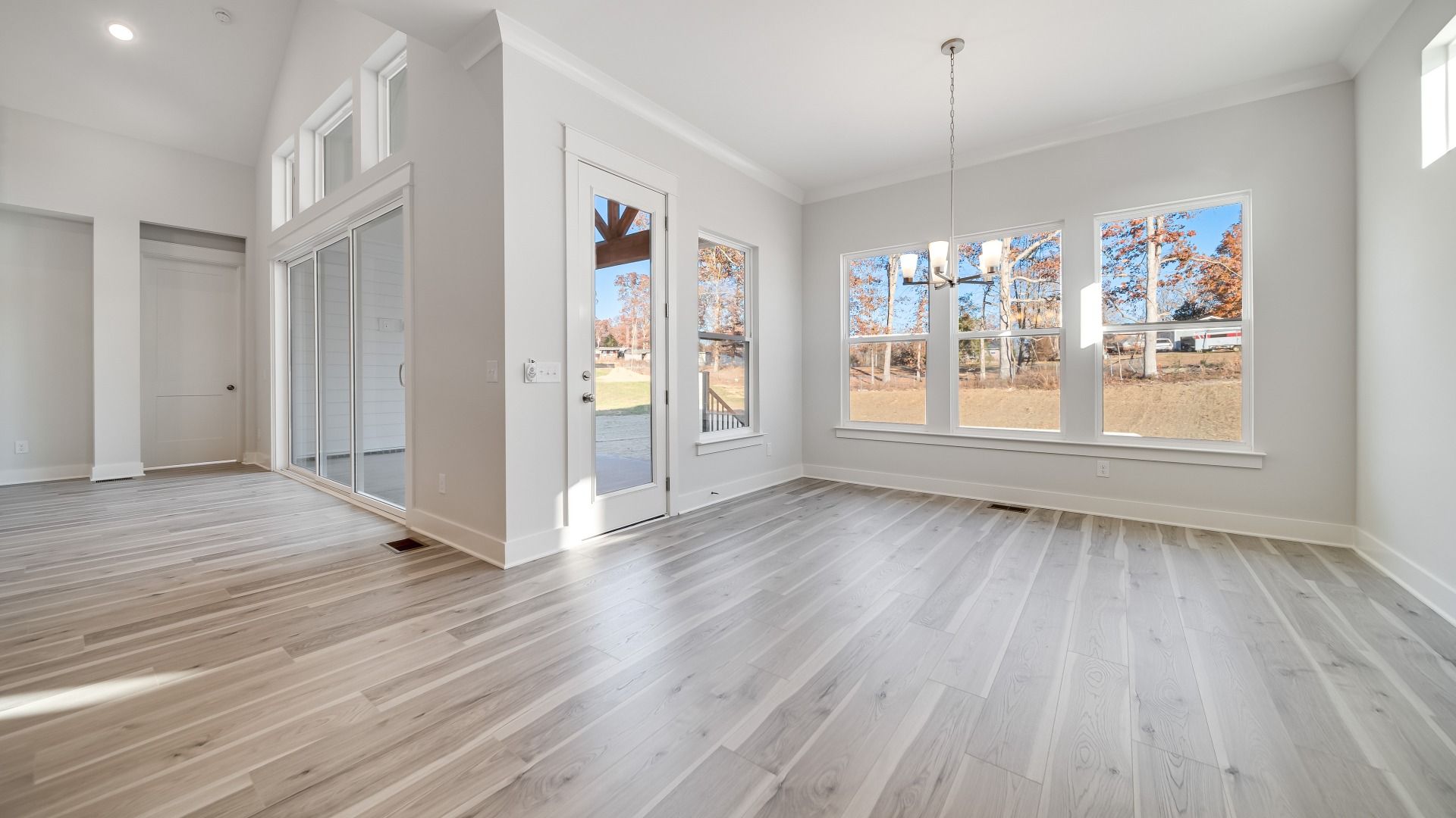 Dining area with chandelier, access to rear entry, and bright natural light
