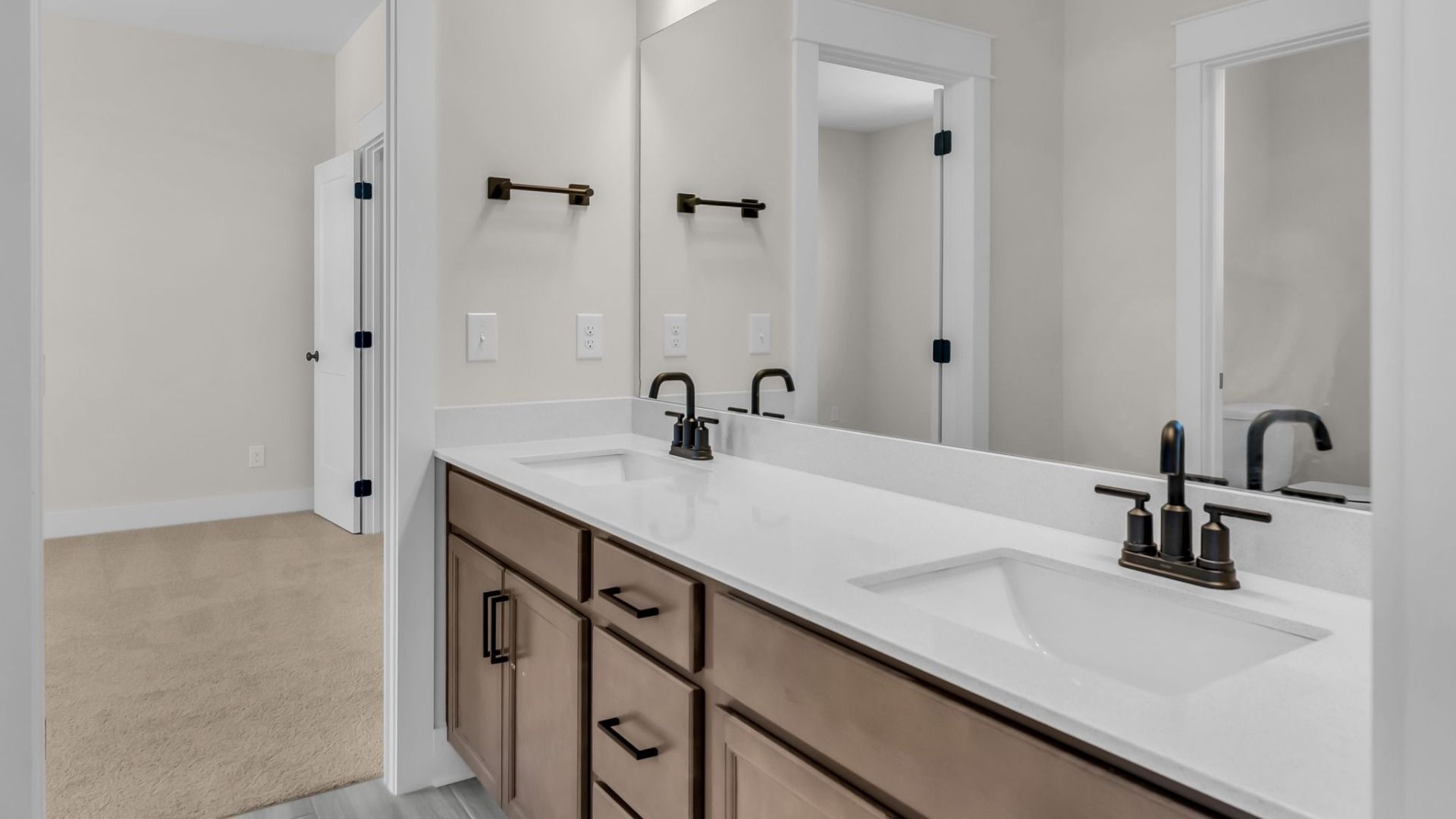 Bathroom with dual vanity and designated area for toilet