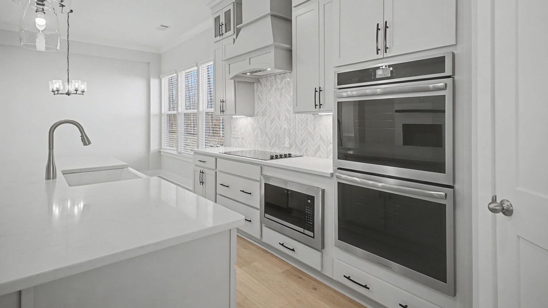 Kitchen with a double stove, light grey cabinetry, beautiful tile backsplash, and stunning view of dining area