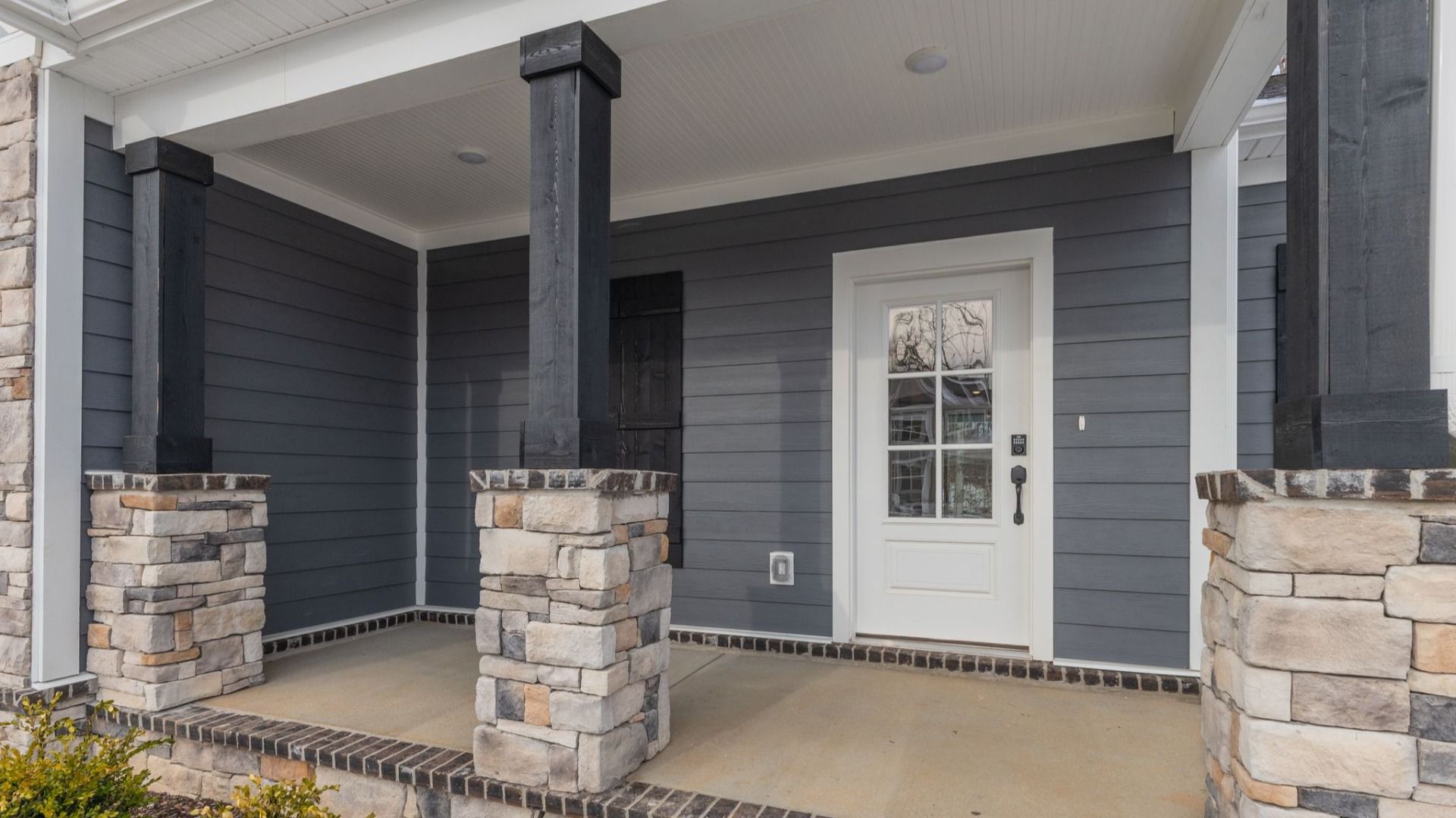 Covered front entryway with blue and stone accents
