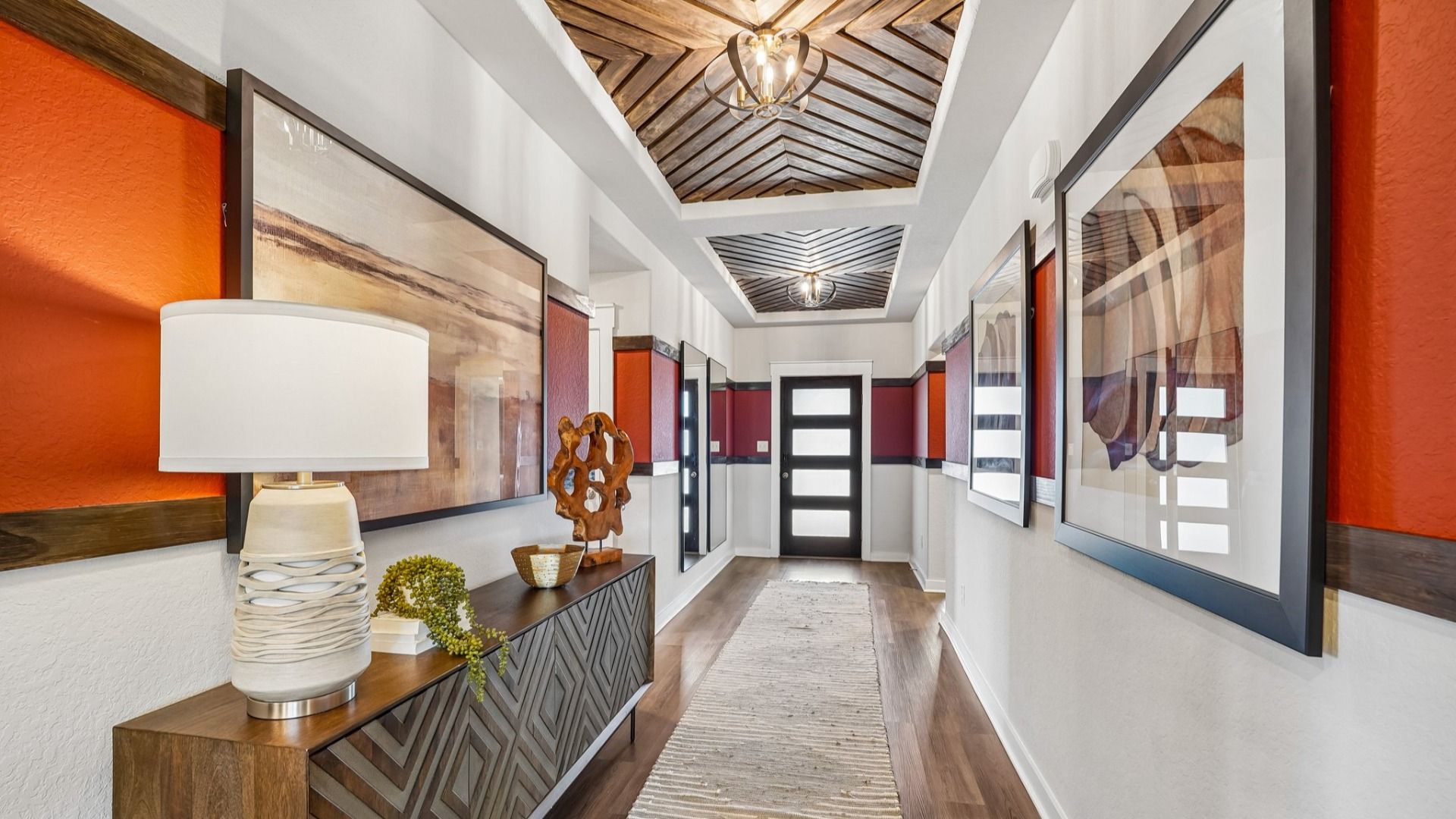 Bold entryway features woodworking details on the ceiling, a modern front door, and wood accents.