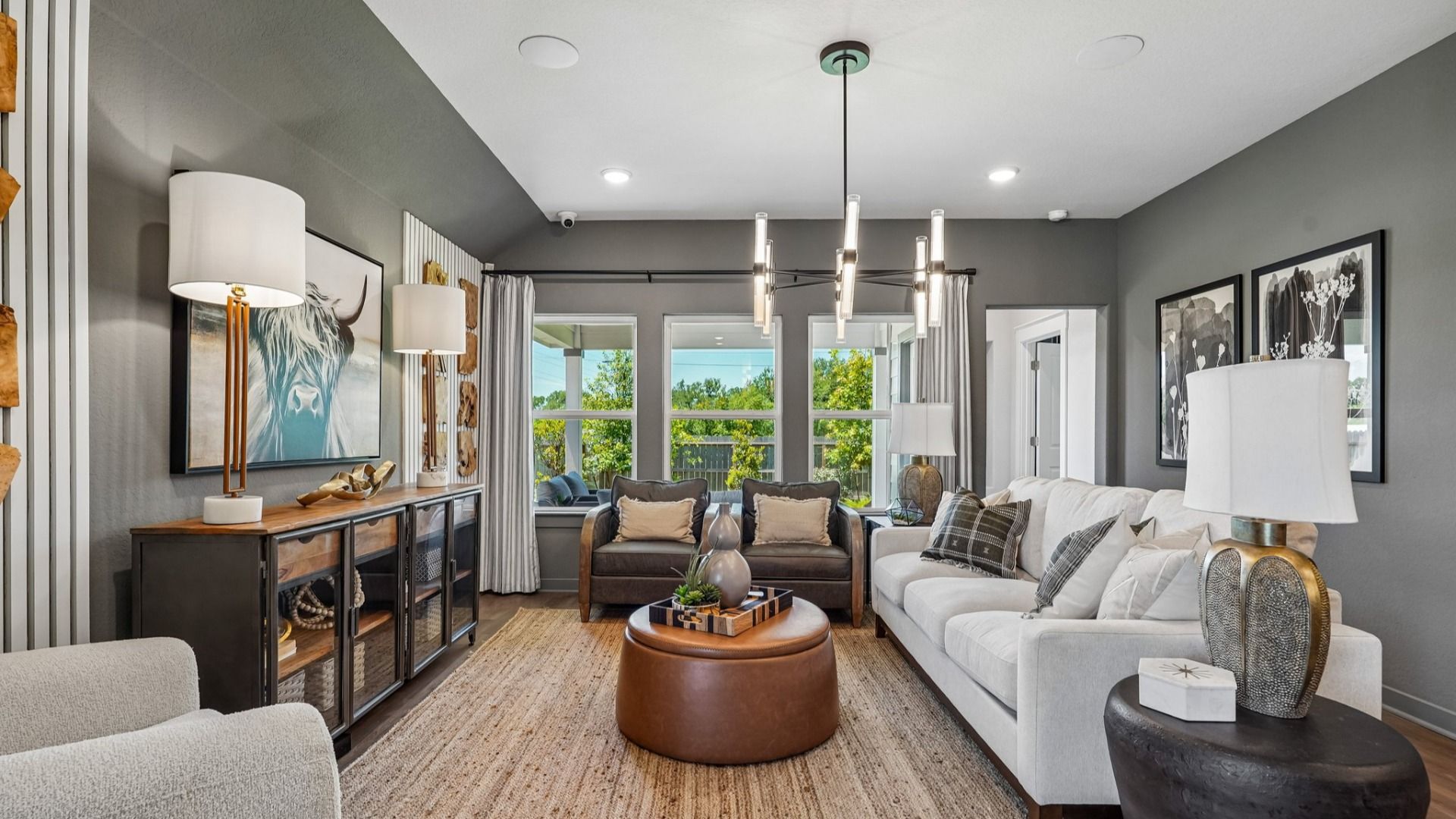 Great Room features a modern chandelier in the center of the room and is open to the kitchen and dining area.