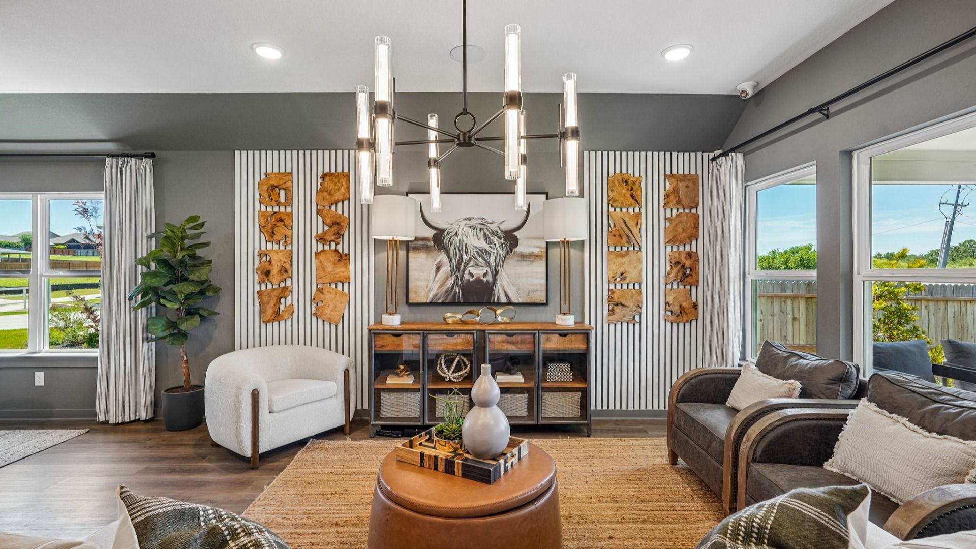 Great Room features a modern chandelier in the center of the room and is open to the kitchen and dining area.