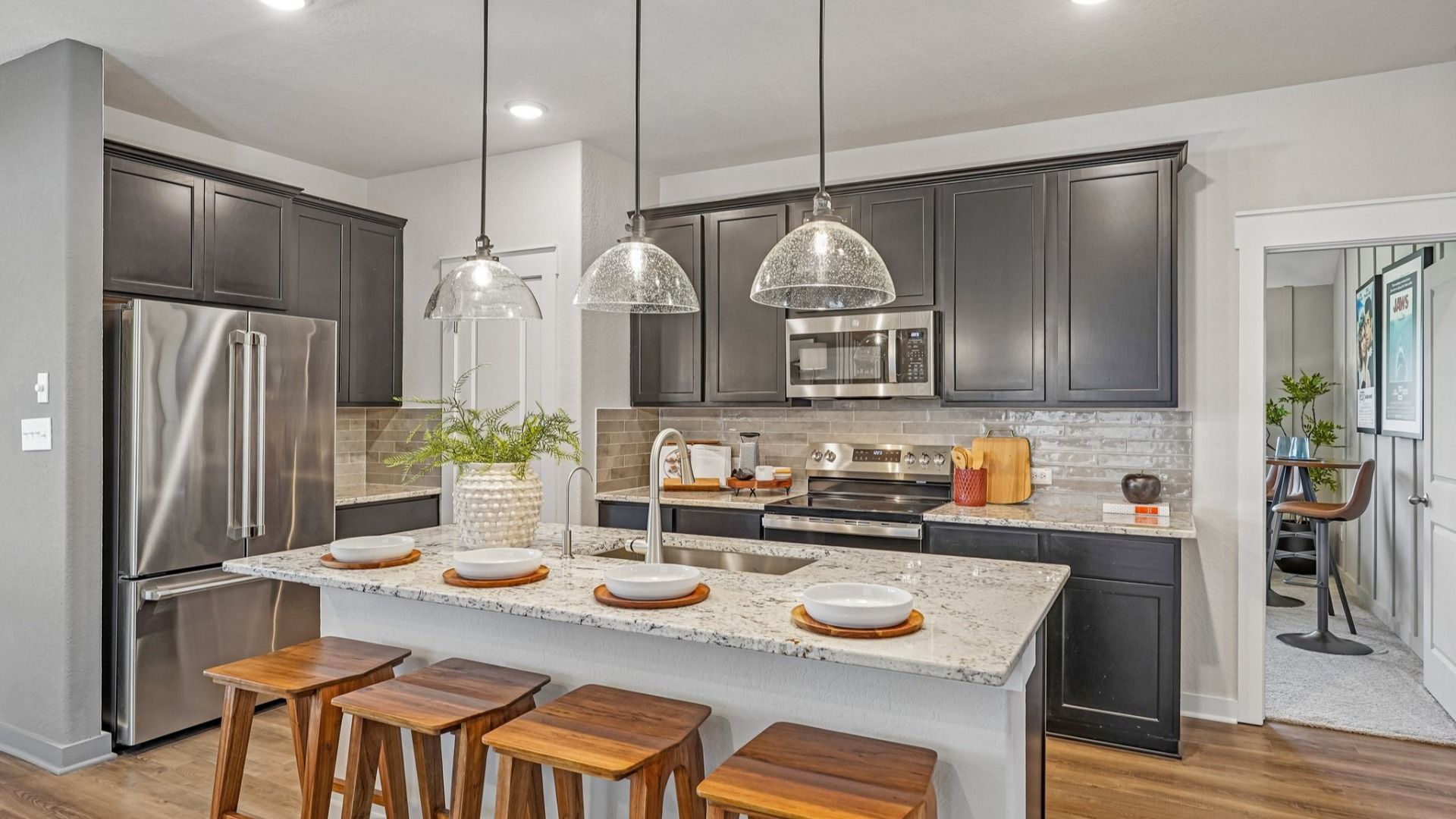 Kitchen features beautiful glass pendant lighting, a center island, and is located near the Flex Room & Laundry