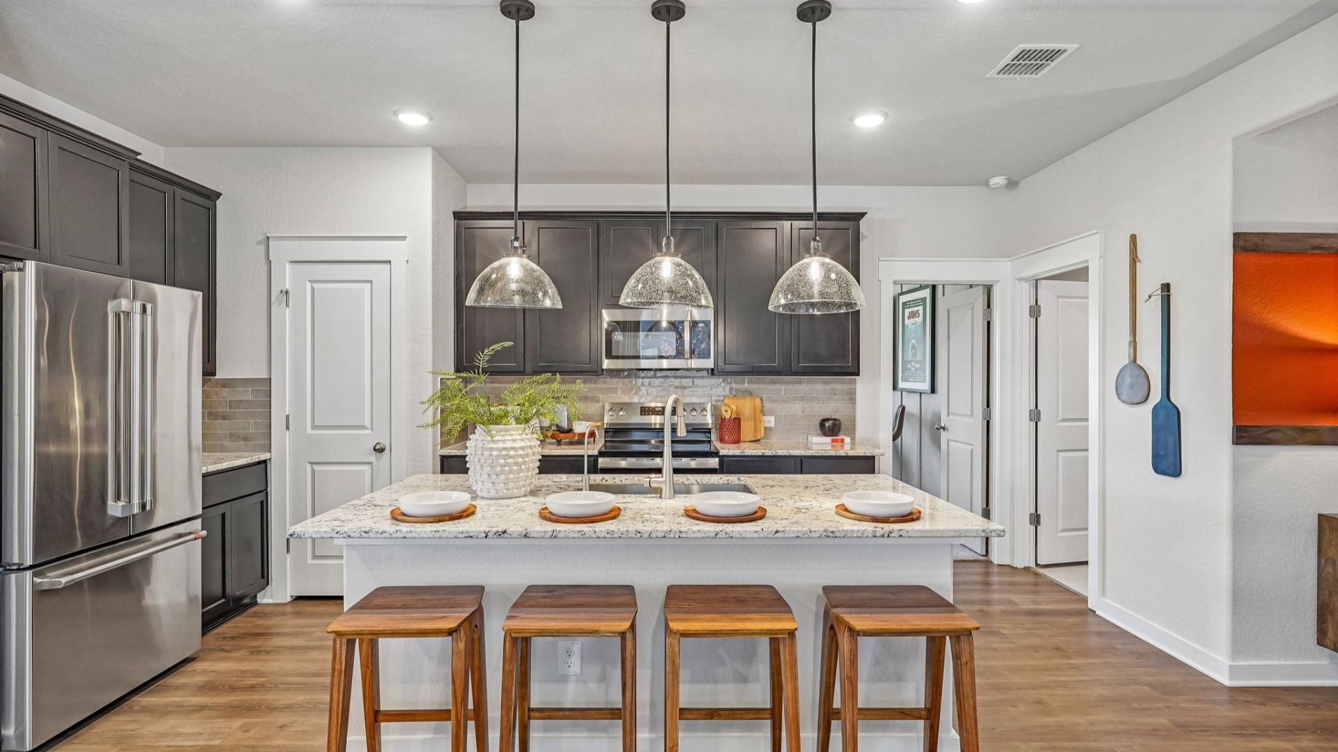 Kitchen features beautiful glass pendant lighting, a center island, and is located near the Flex Room & Laundry