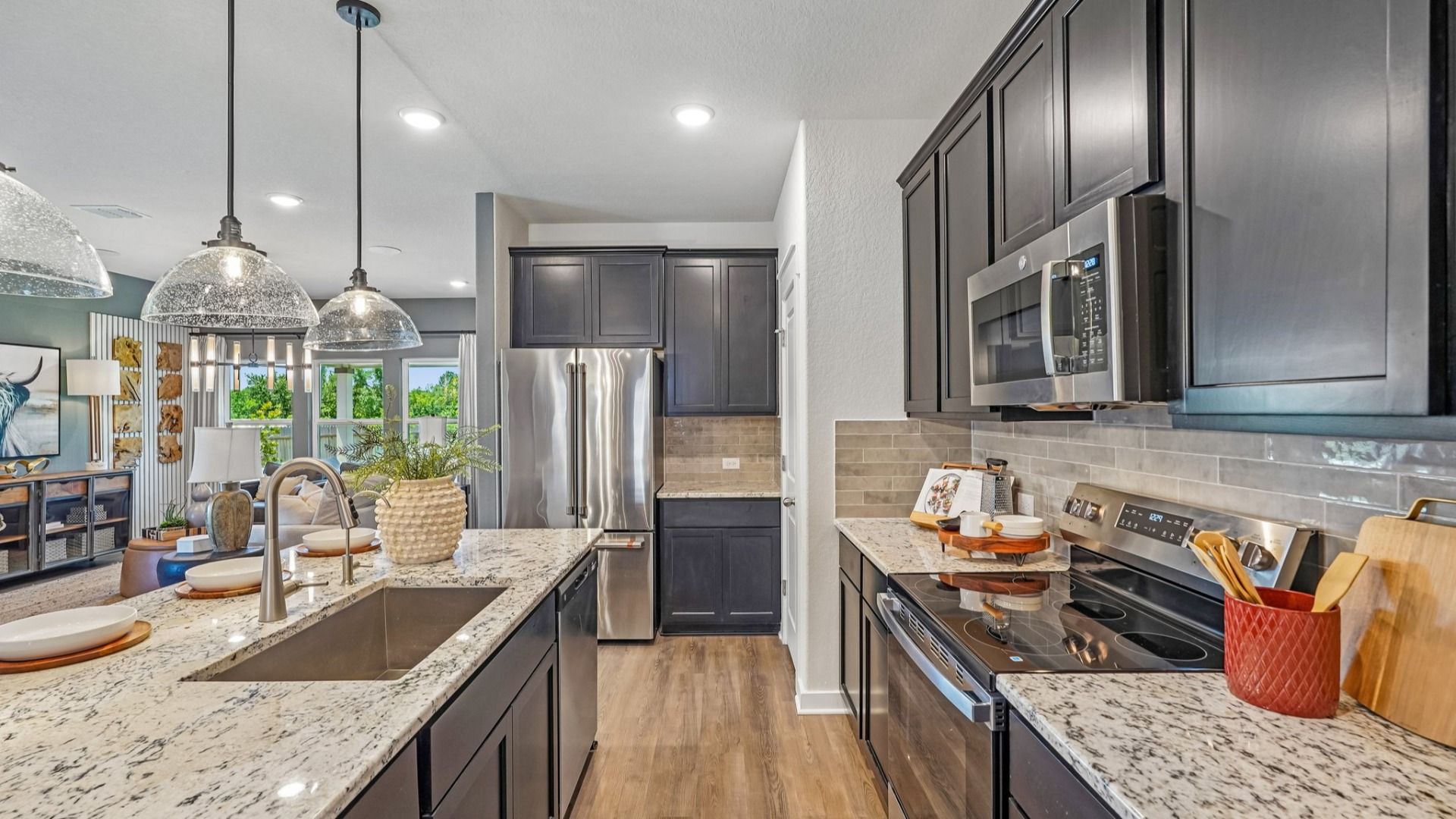 Kitchen features beautiful glass pendant lighting, a center island, and is located near the Flex Room & Laundry