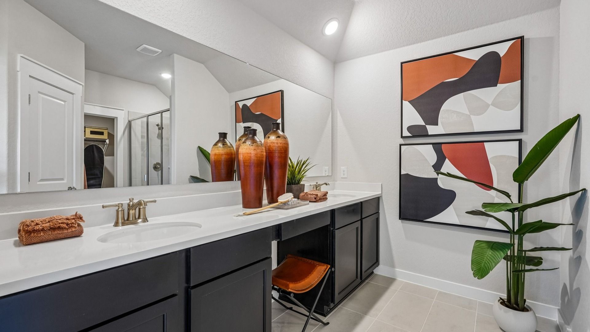 Ample counter space at the Owner's Bath, with dual vanity, space for chair, and an oversized mirror.