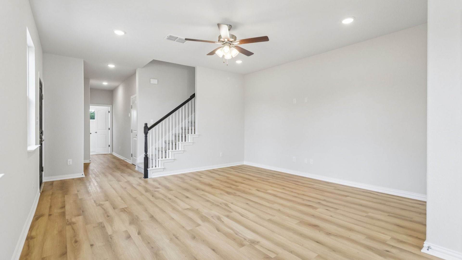 Spacious Great Room with Ceiling Fan and a partial view of the stairway