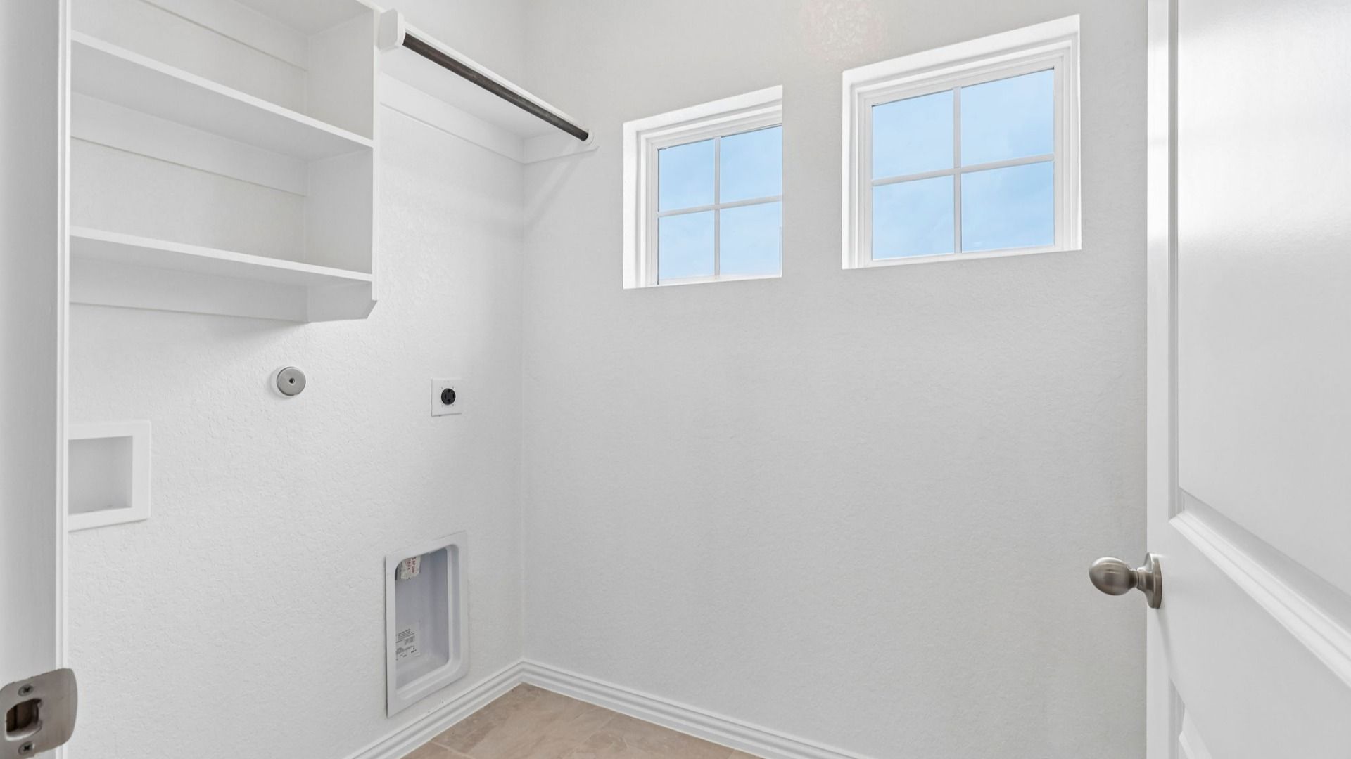 Laundry with built-in shelving and windows for natural light