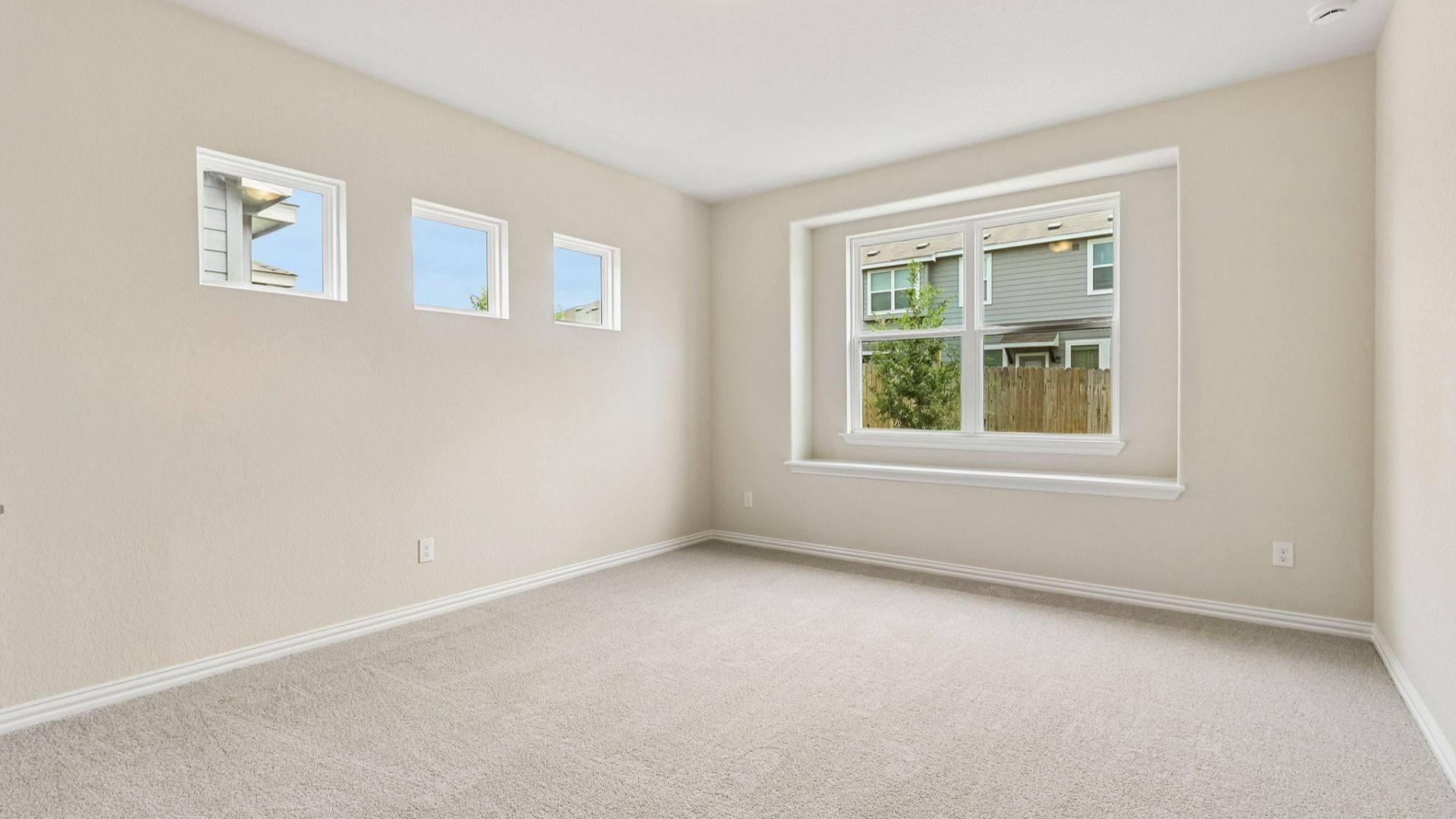 Owner's Suite has a large window with architectural detail and is located on the main level of the home