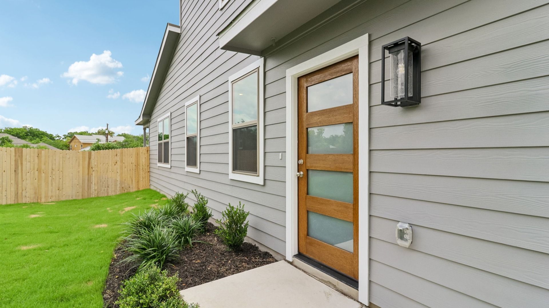 Side Entry with stained wood door and modern glass panels
