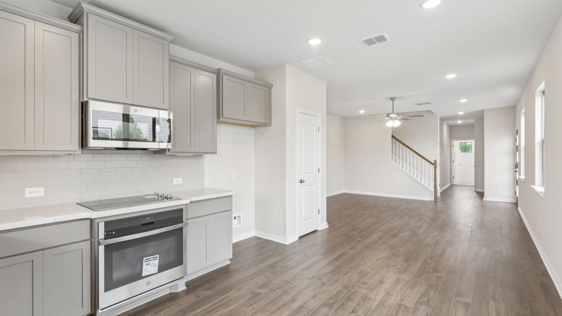 Kitchen is bright with 42 inch grey cabinetry, sleek complimentary white countertops, and stainless steel appliances