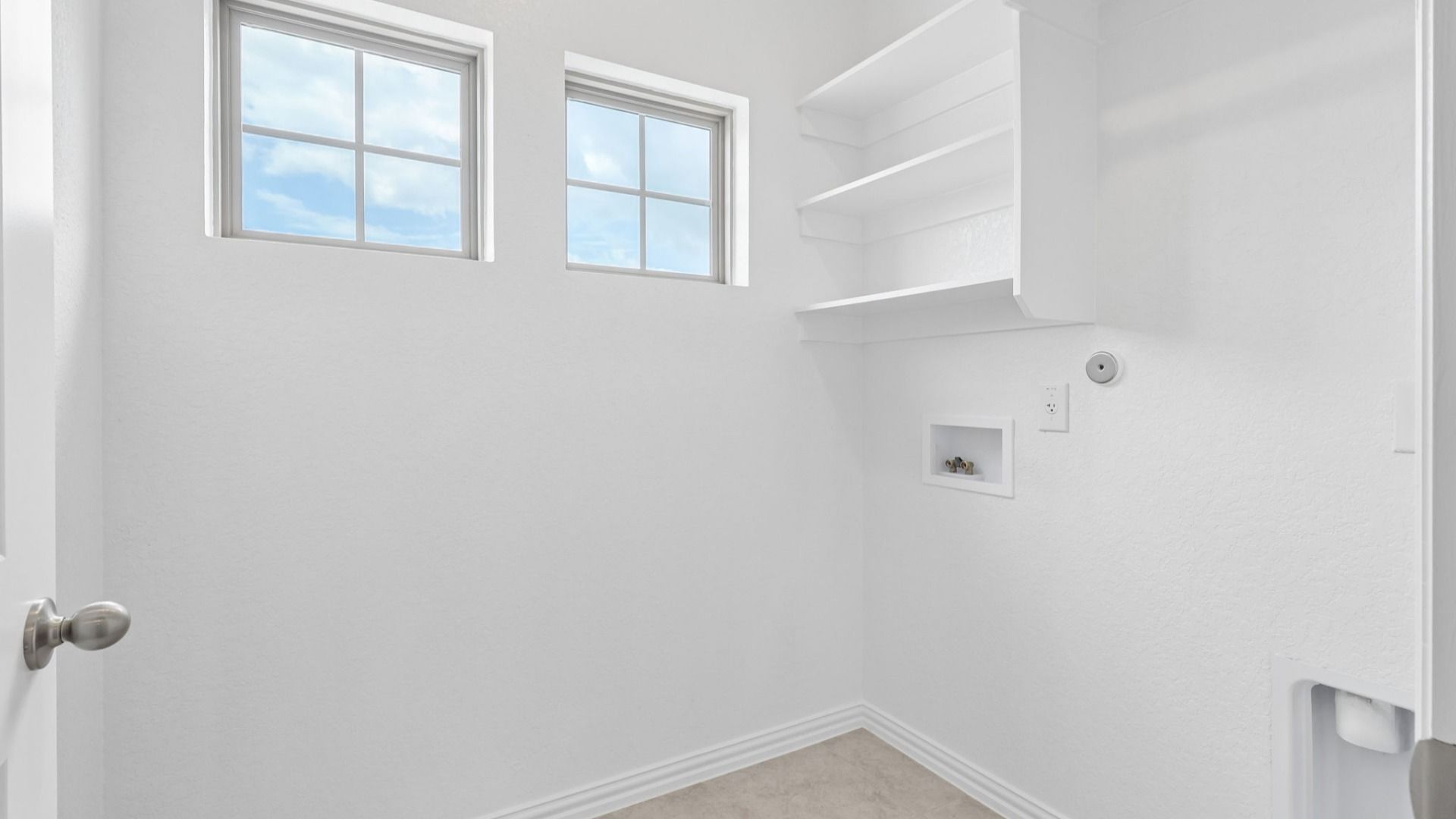 Laundry with built-in shelving and windows for natural light