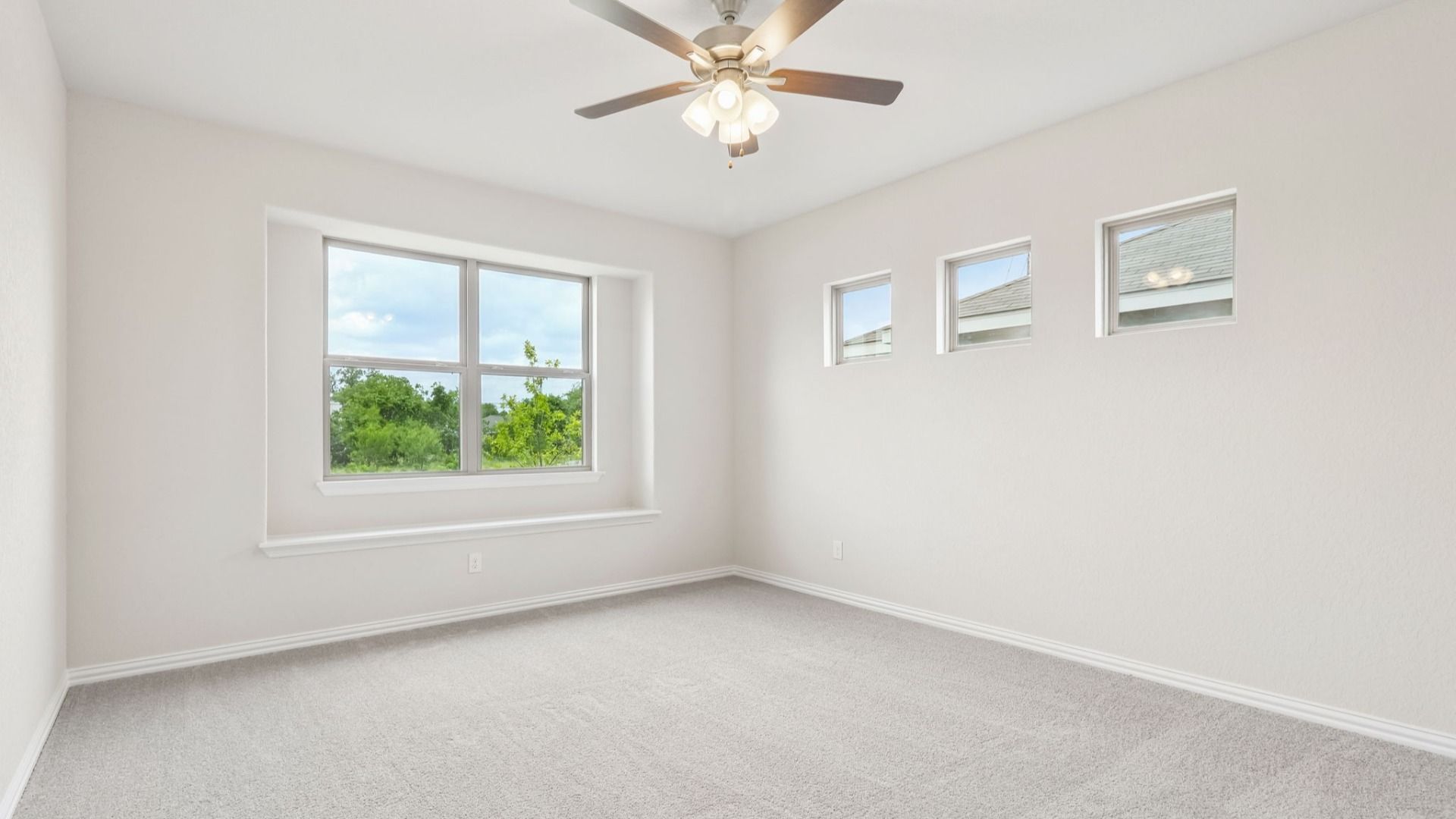 Owner's Suite has a large window with architectural detail and is located on the main level of the home