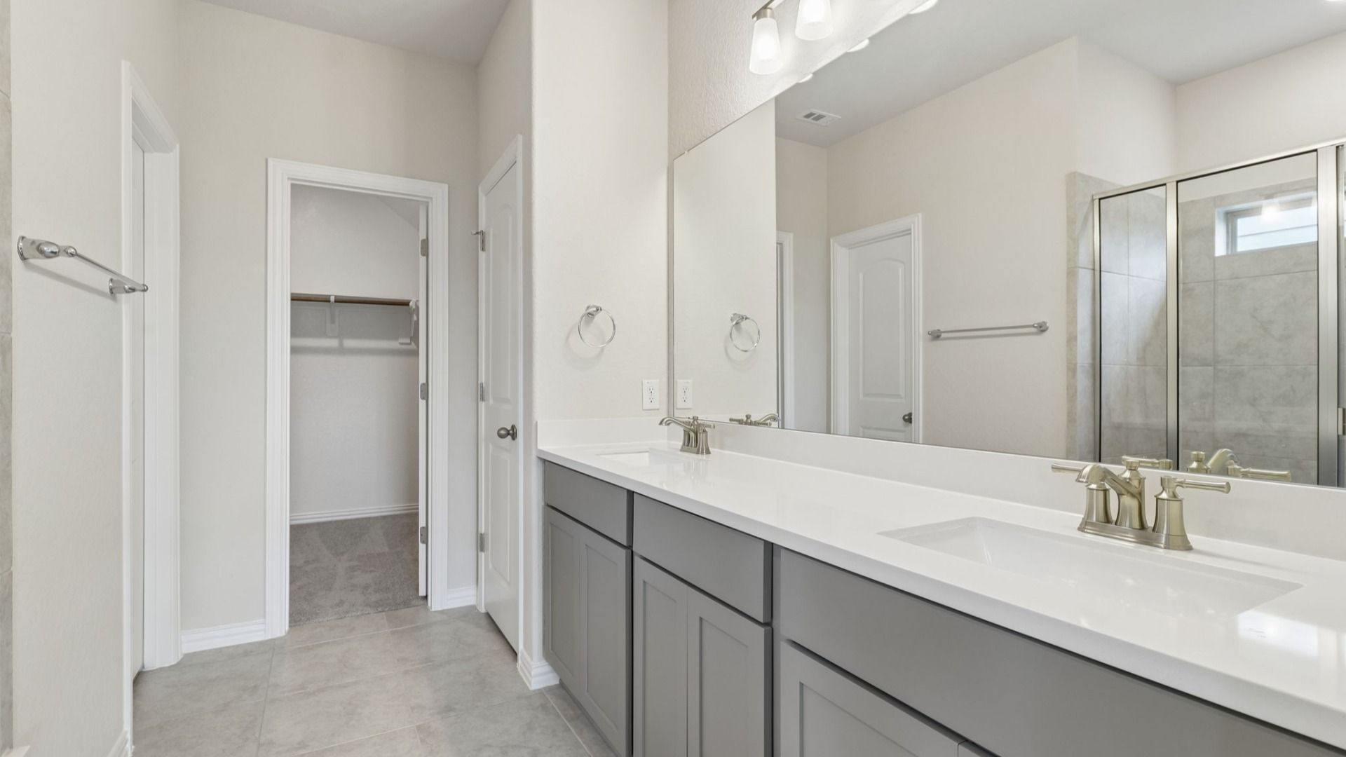 Owner's Bath has grey cabinets, dual vanity and a large shower with a window for natural light