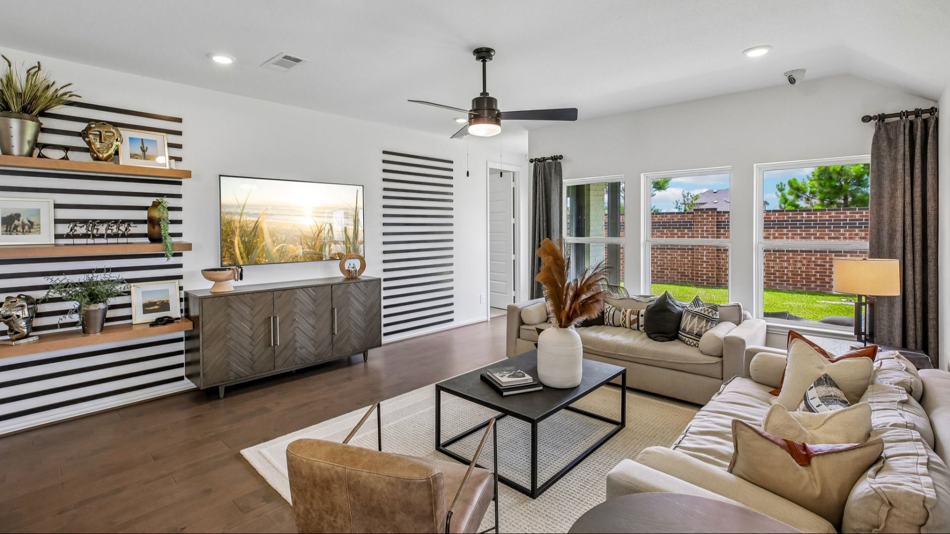 Luxurious living room in Cypress Green featuring a chic striped wall, stylish furnishings, and expansive windows.