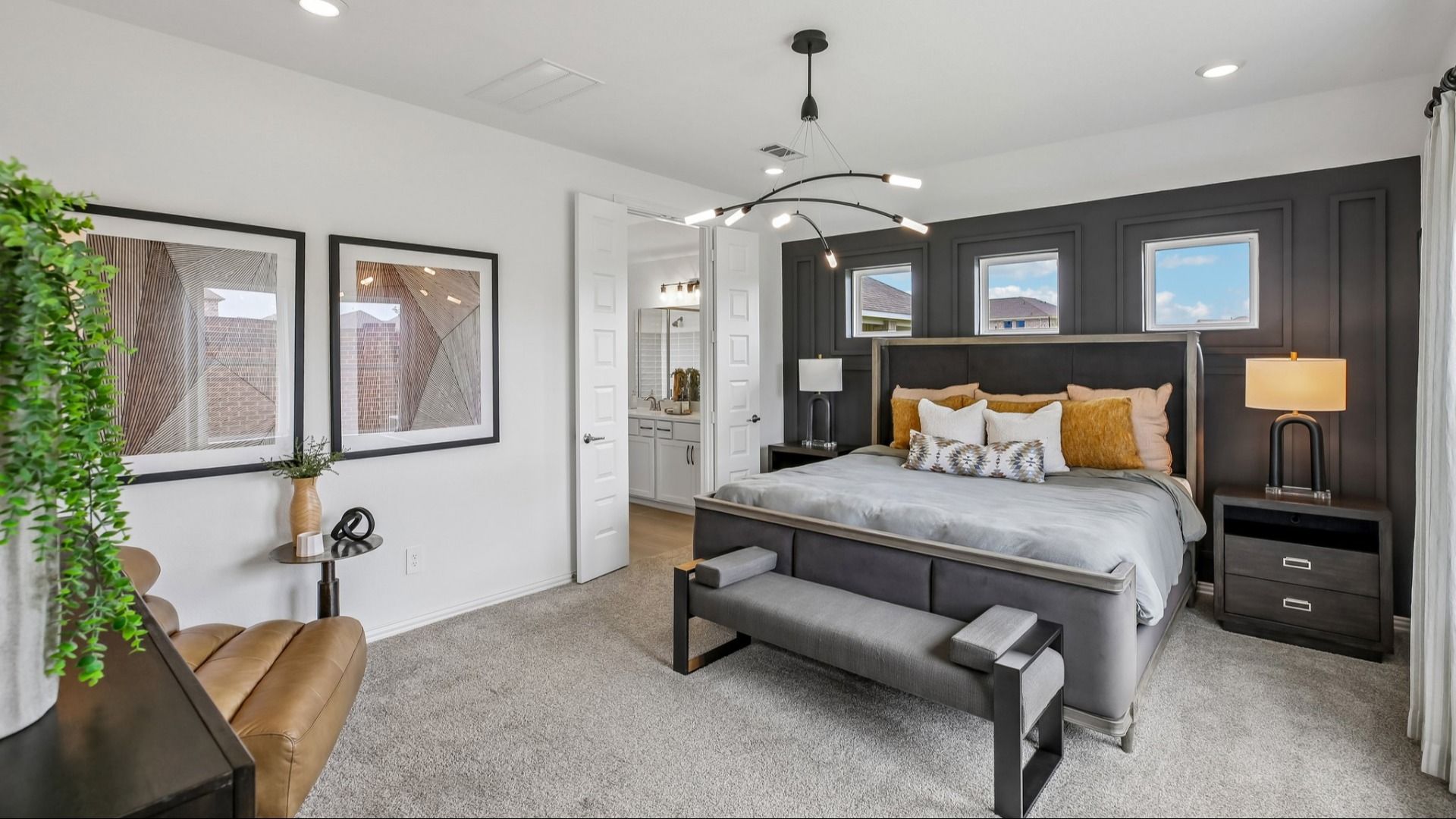 Luxurious bedroom with rich wood accent wall, stylish chandelier, plush carpet in Cypress Green.