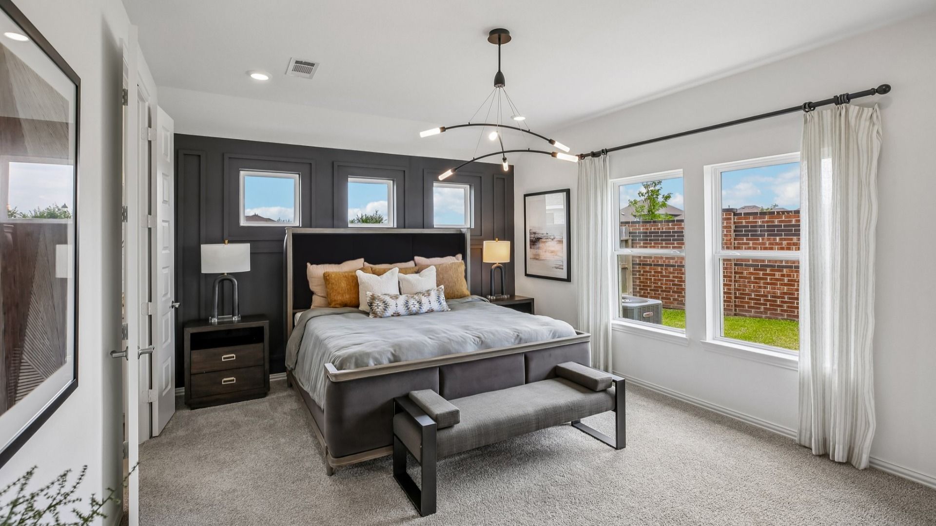 Elegant bedroom with modern lighting fixtures and plush textiles in Cypress Green community.