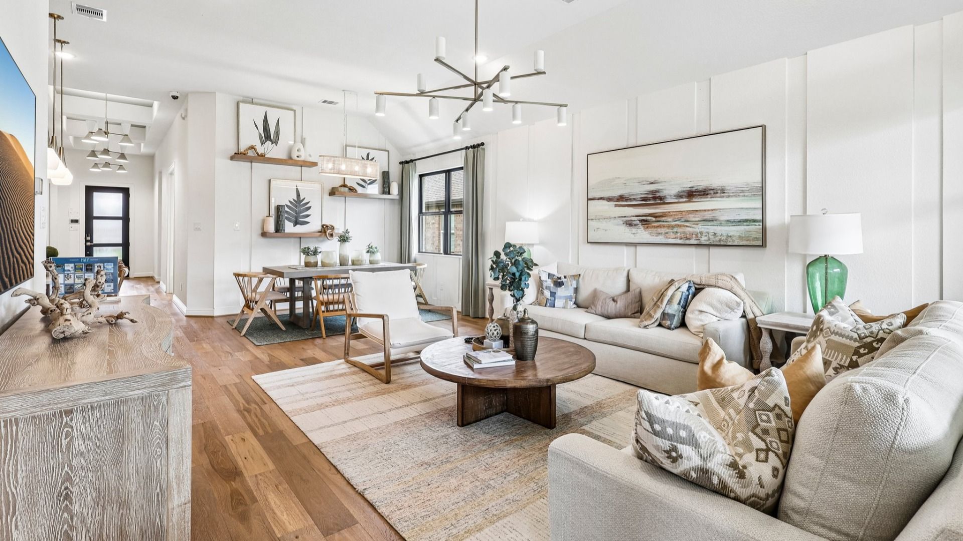 Elegant Sunterra living room boasts chic lighting, seamless hardwood floors, and refined finishes in Houston.