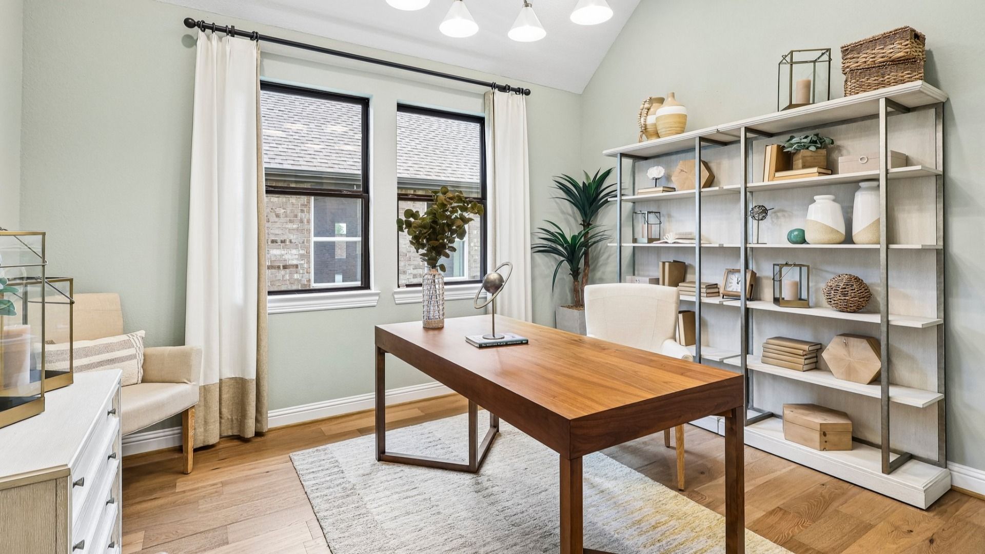 Elegant office with sleek wooden desk and expansive windows in Sunterra community.