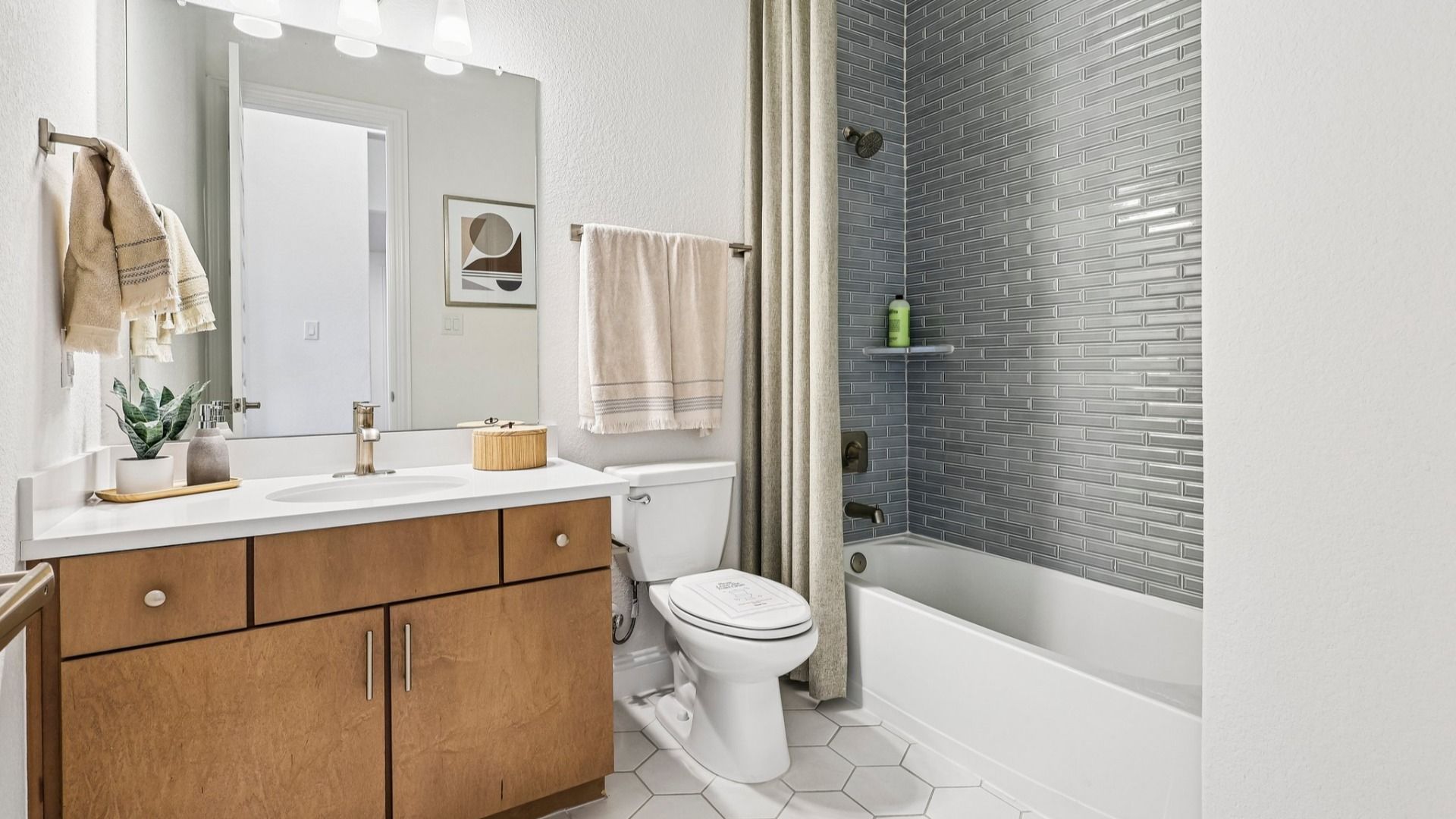 Sleek bathroom features modern vanity, luxurious tiling, and refined finishes in Sunterra community.