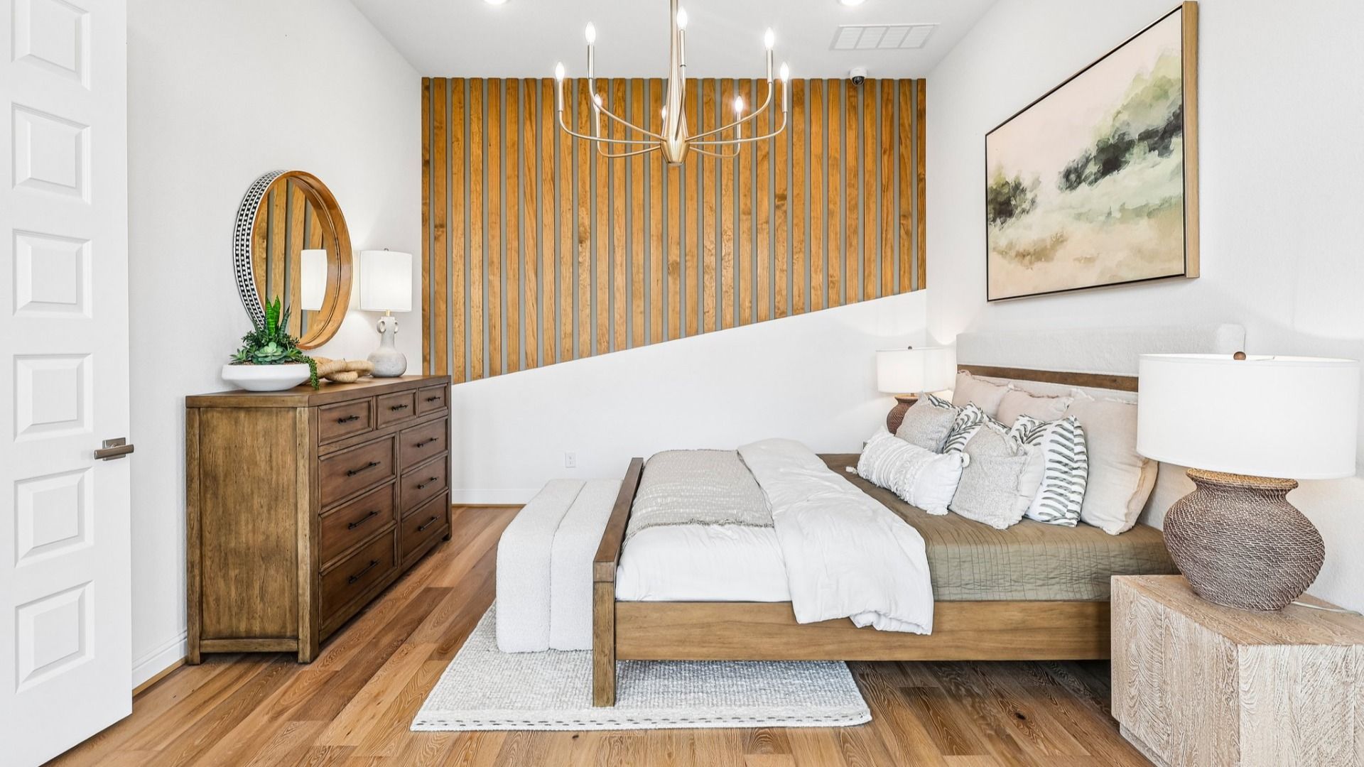 Luxury Sunterra bedroom boasts a tray ceiling, sophisticated accent wall, and plush bedding for a serene retreat.