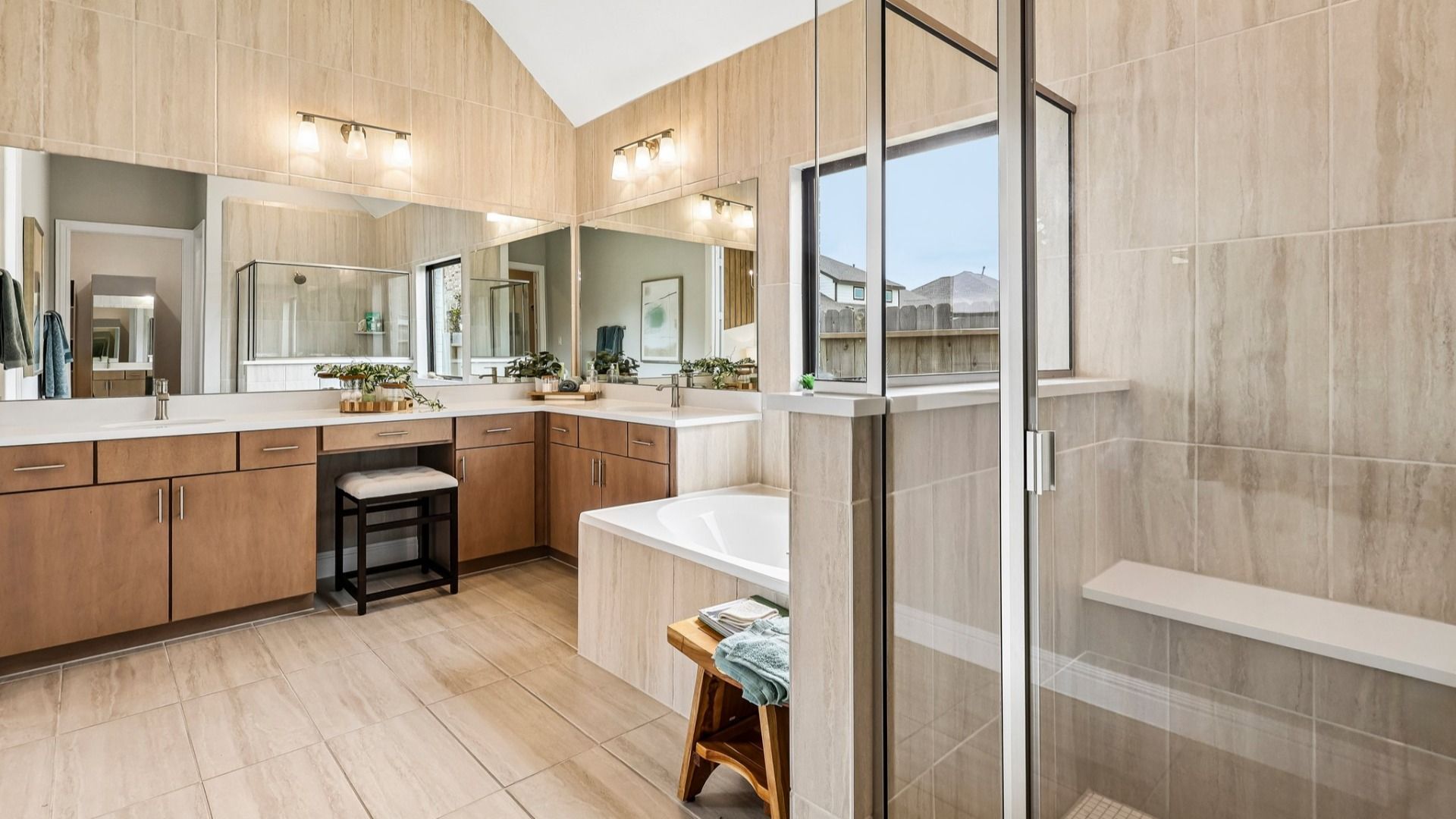Indulge in the Sunterra community’s luxurious bathroom with a sleek glass shower and refined wood cabinetry.
