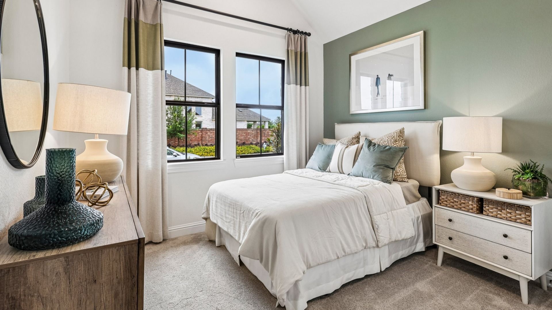 Sunterra bedroom boasts vaulted ceilings, elegant pale green accent wall, and expansive windows for airy luxury.