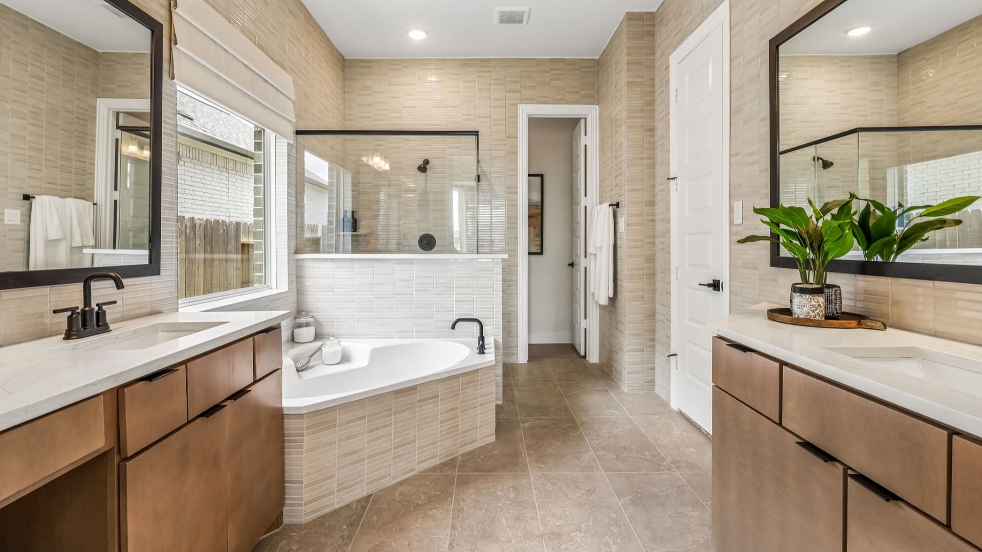 Luxurious Brookewater bathroom with marble tiles, dual vanity, and frameless glass shower. Opulent design elements.