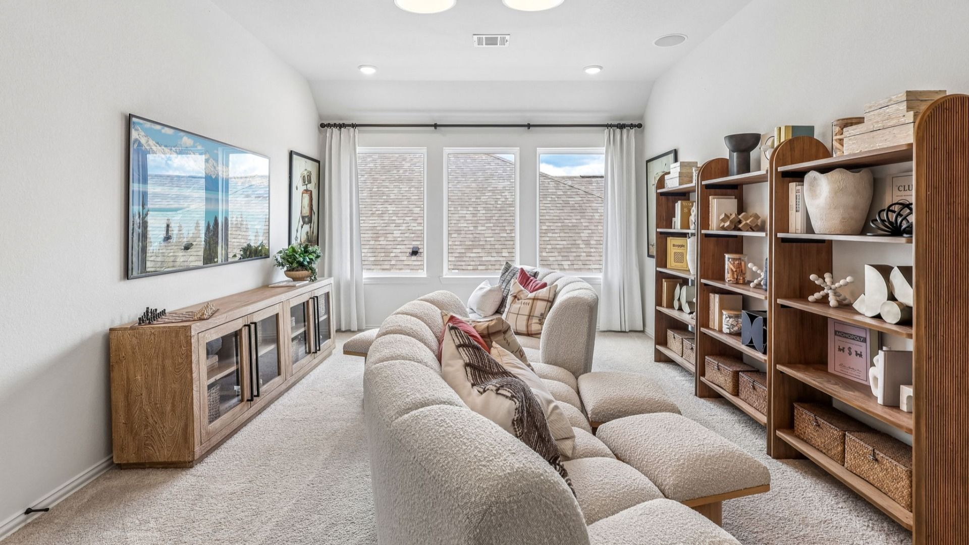 Luxurious living area with plush seating, bespoke wood shelving, and ample natural light in Brookewater.