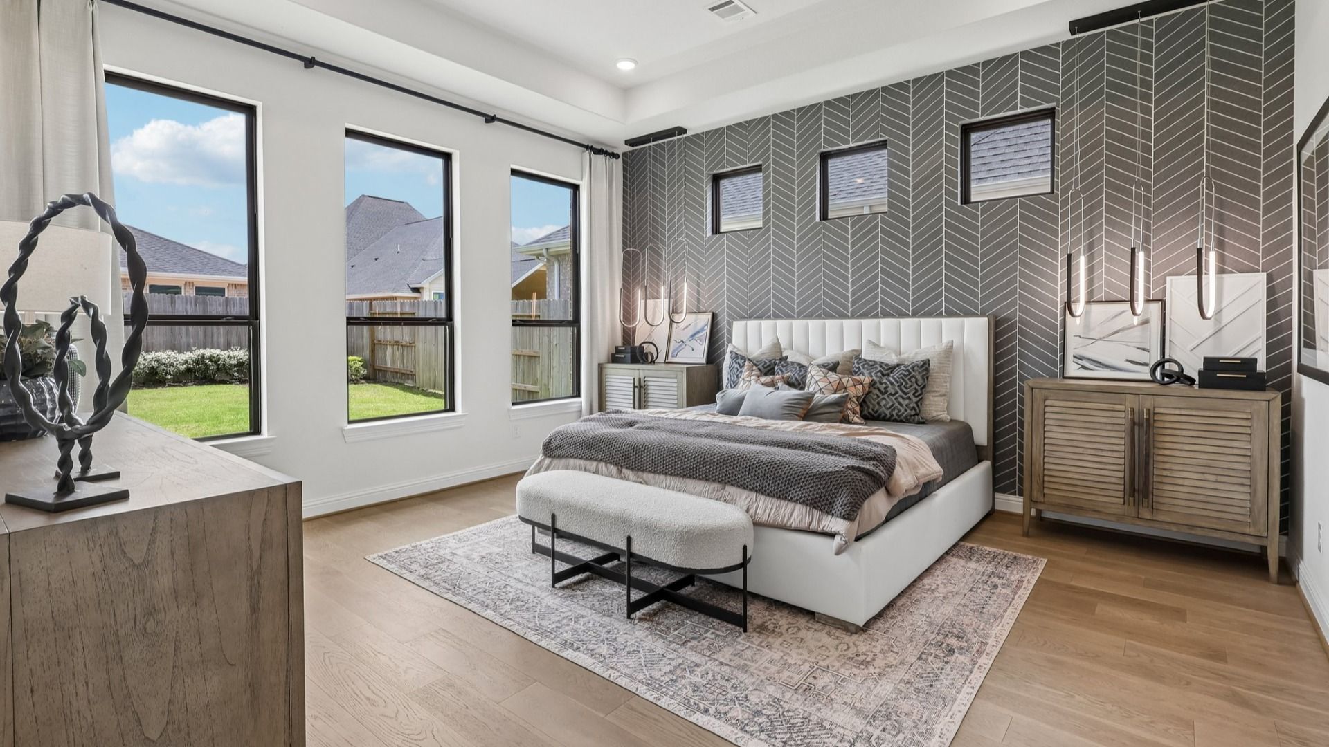 Luxurious room features a striking herringbone accent wall and large windows, exuding elegance in Brookewater.