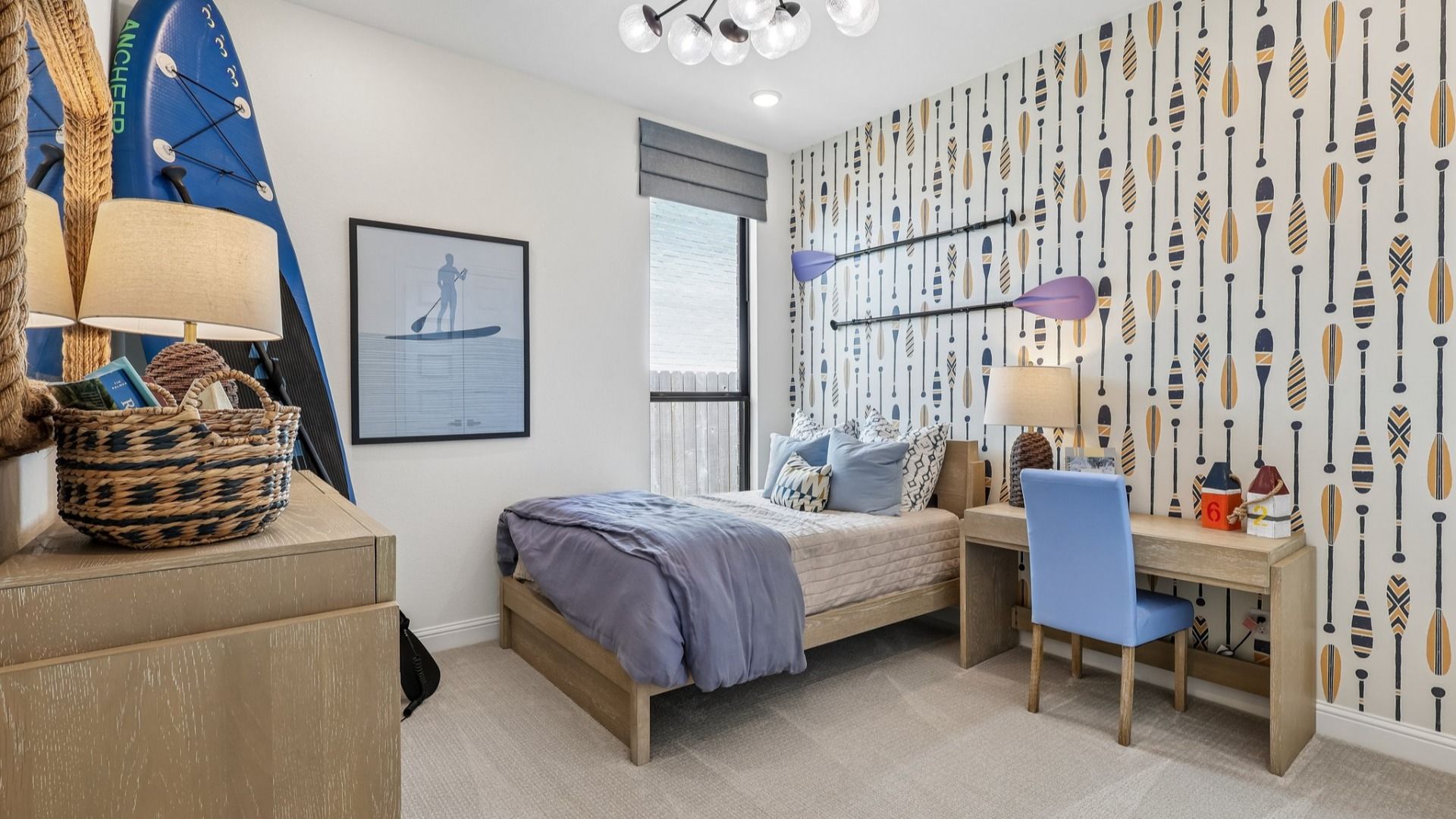Paddle-themed wallpaper and chic chandelier in Brookewater make this bedroom an exquisite retreat.