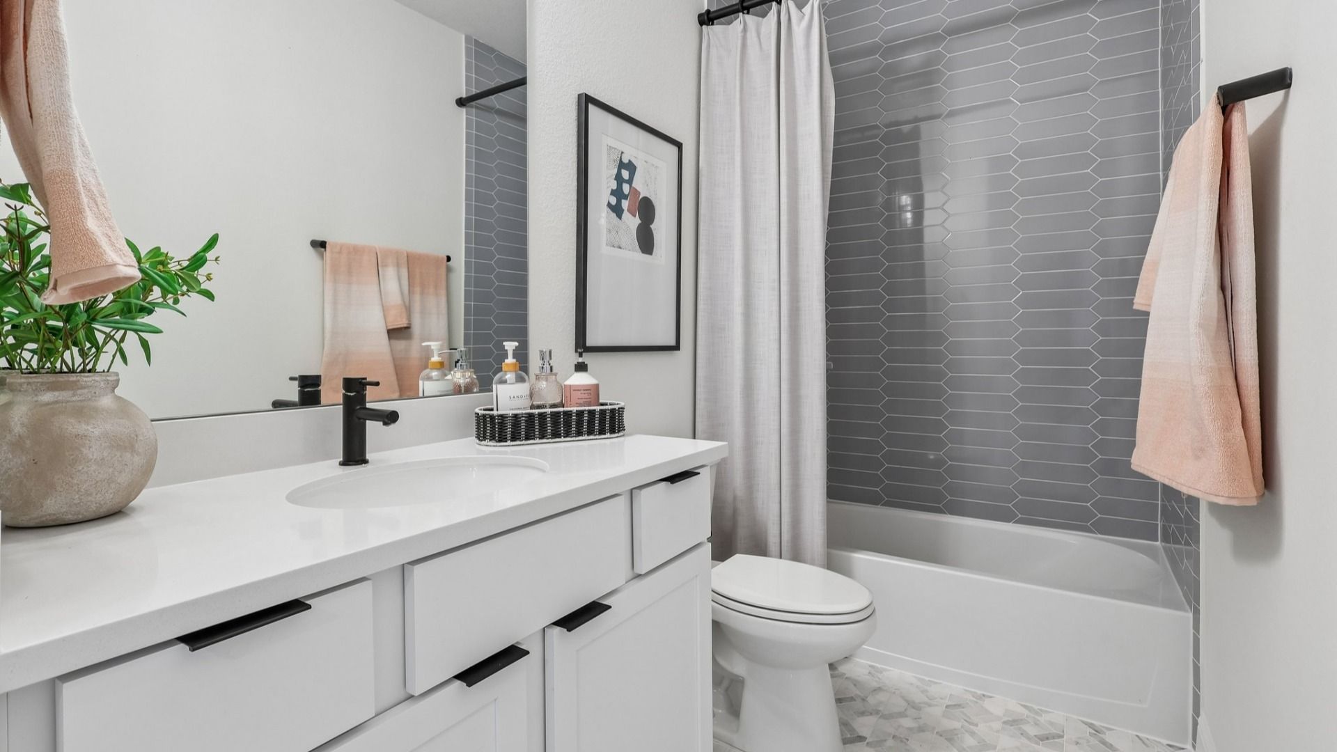 Stylish bathroom with elegant hexagon tiles and sleek matte black fixtures in prestigious Brookewater community.