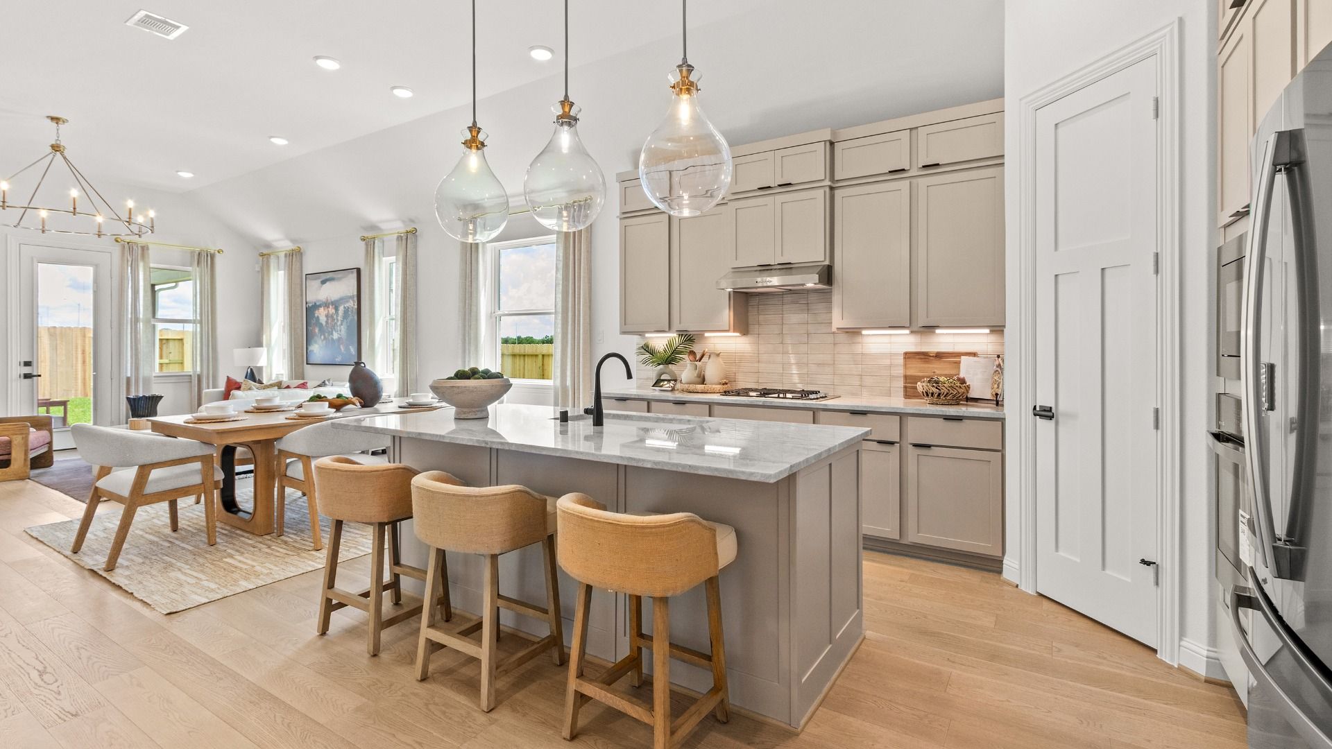 Modern kitchen showcasing neutral beige cabinetry, sleek countertops, and a bright, open design.