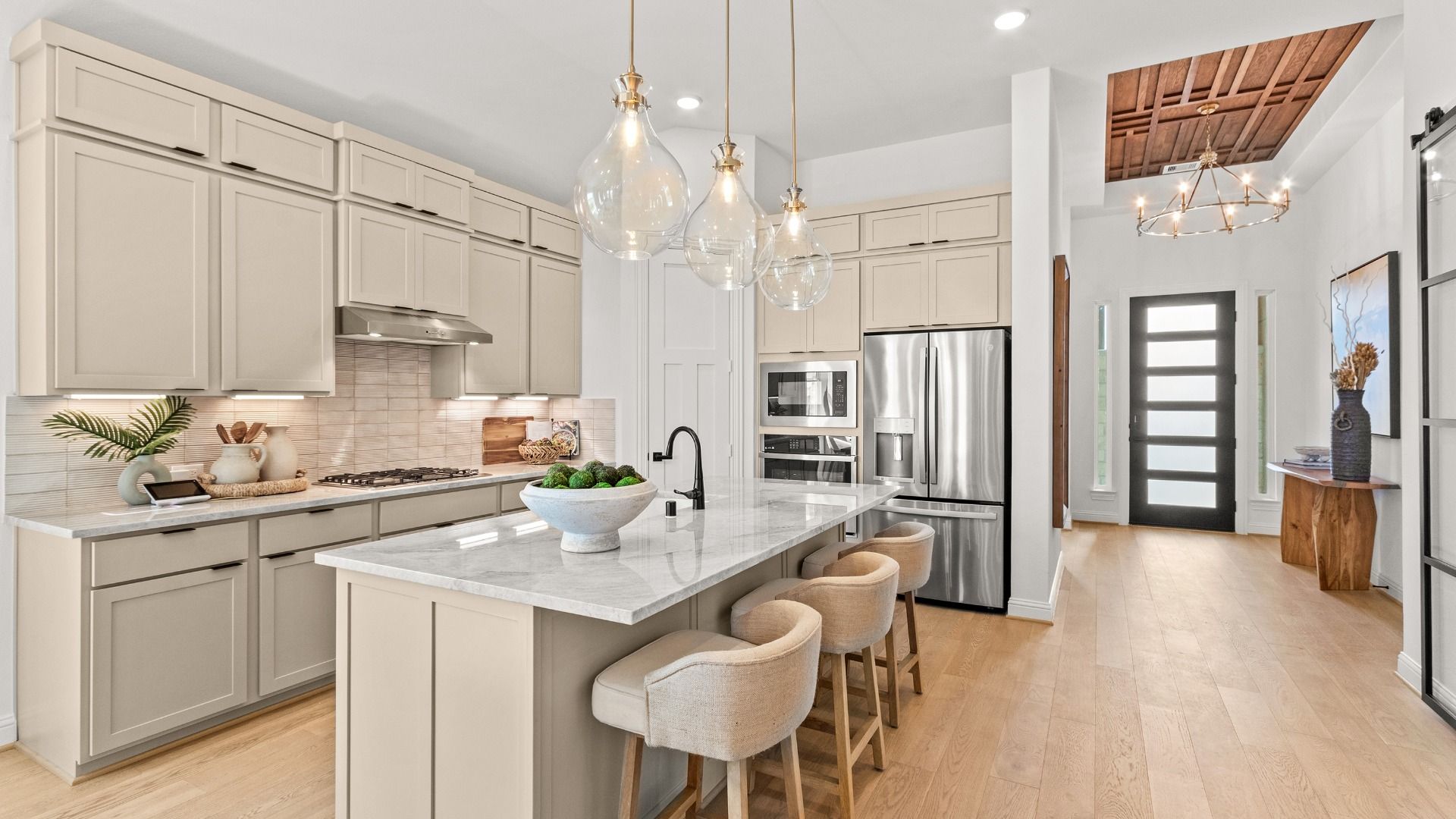Bright kitchen featuring a large granite island with a stylish backsplash and modern finishes.