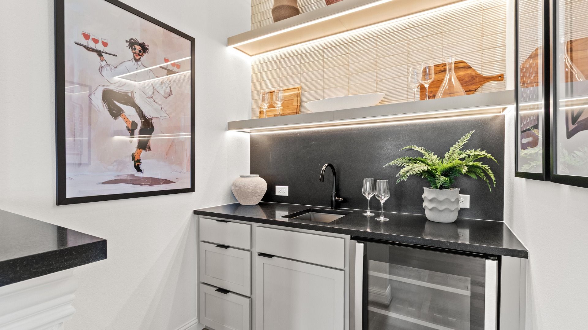 This stylish wet bar in Azalea combines sleek bold surfaces with modern design for a refined entertaining space.