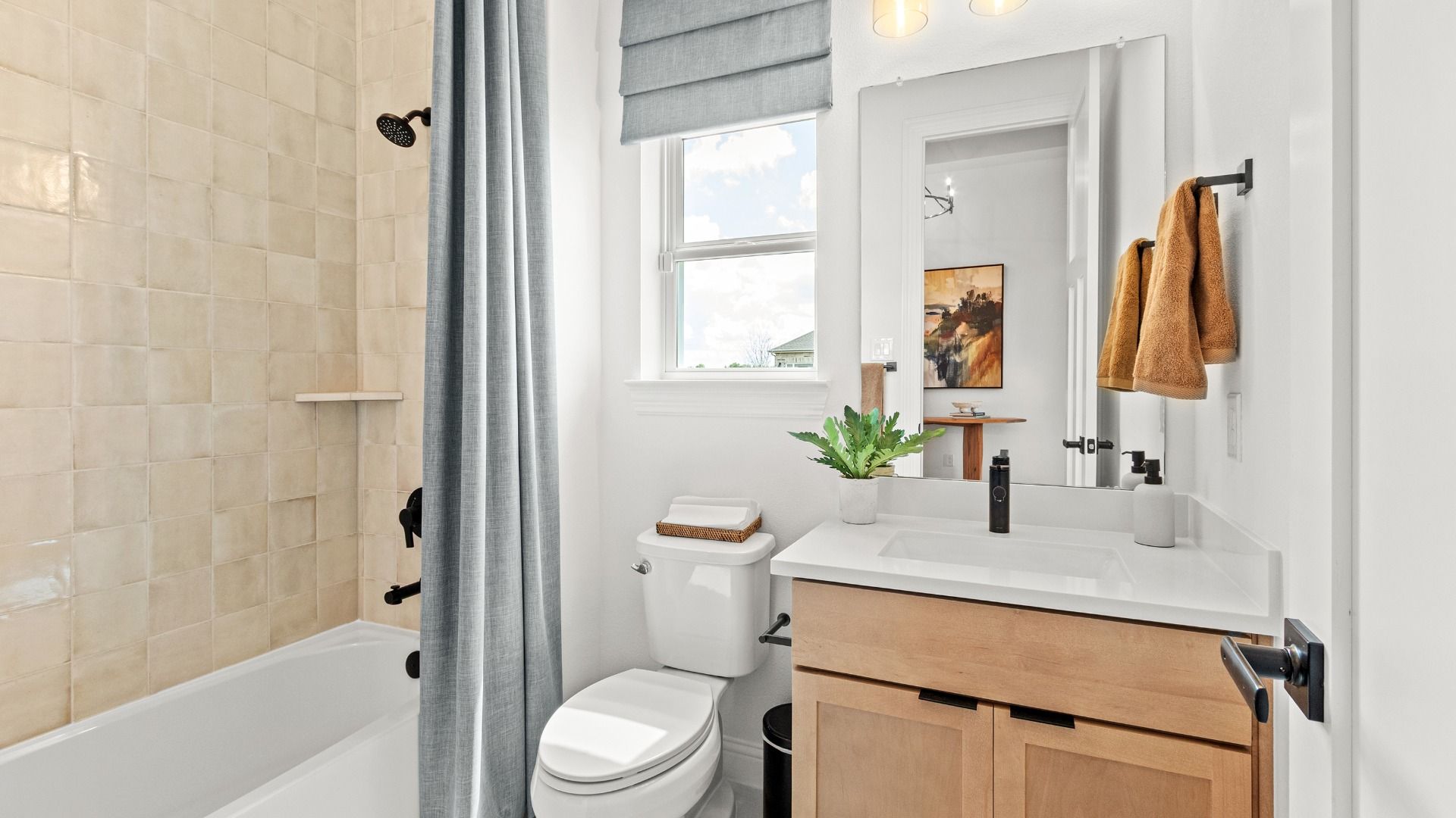 Bright tile walls and matte black fixtures create a fresh, clean aesthetic in this stylish bathroom.