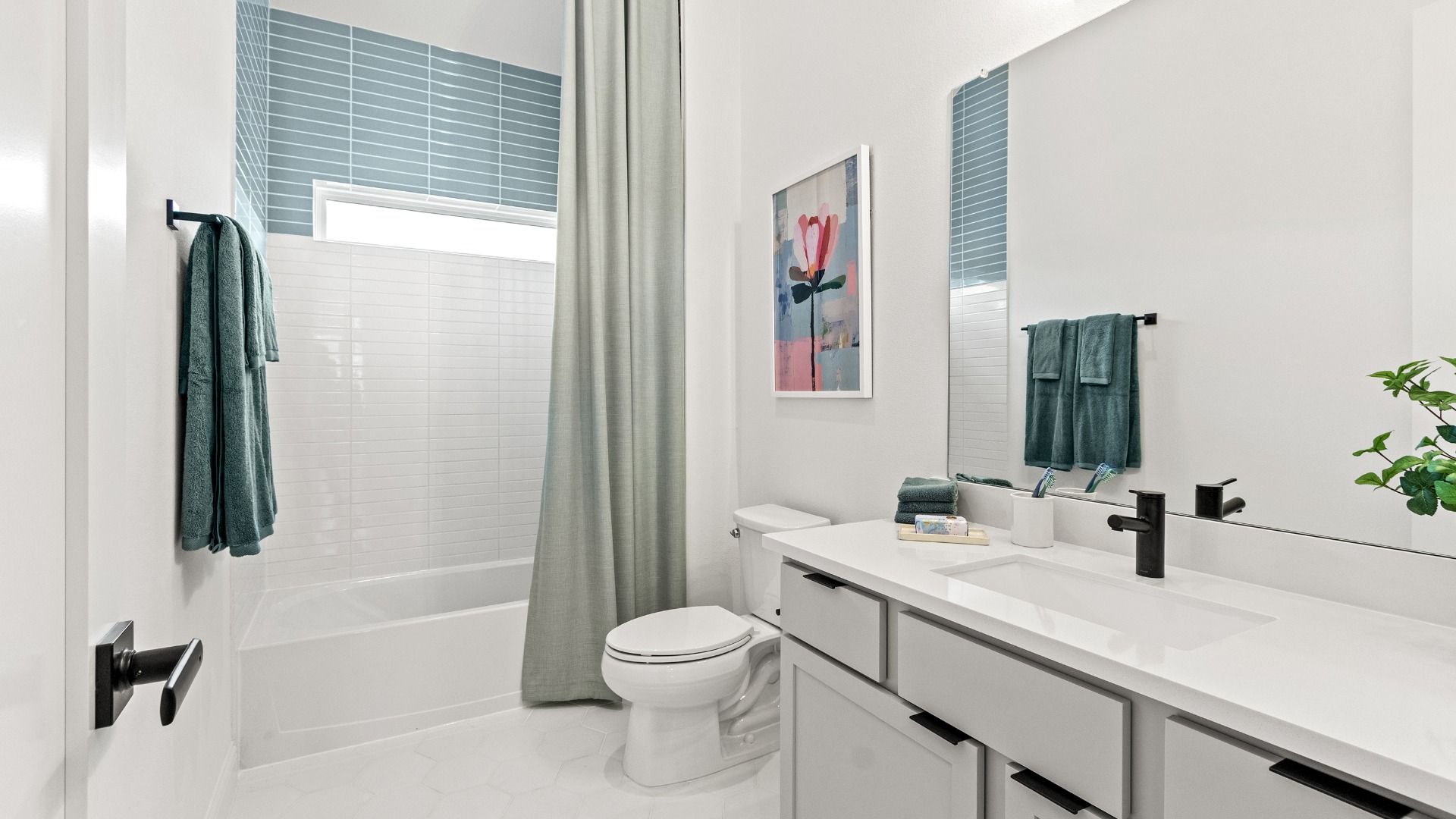 Crisp white and blue tiling with bold black finishes create a fresh, modern contrast in this stylish bathroom.