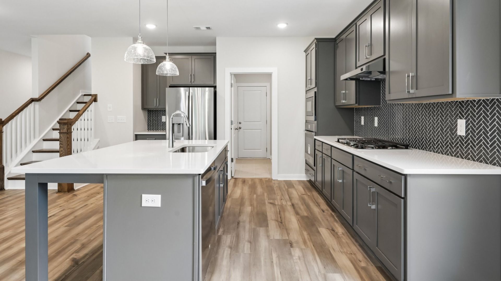 Kitchen with hard surface flooring, quartz countertops, and pendant lighting