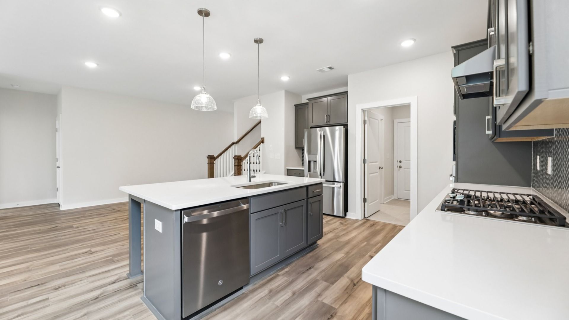 Kitchen with hard surface flooring, quartz countertops, and pendant lighting