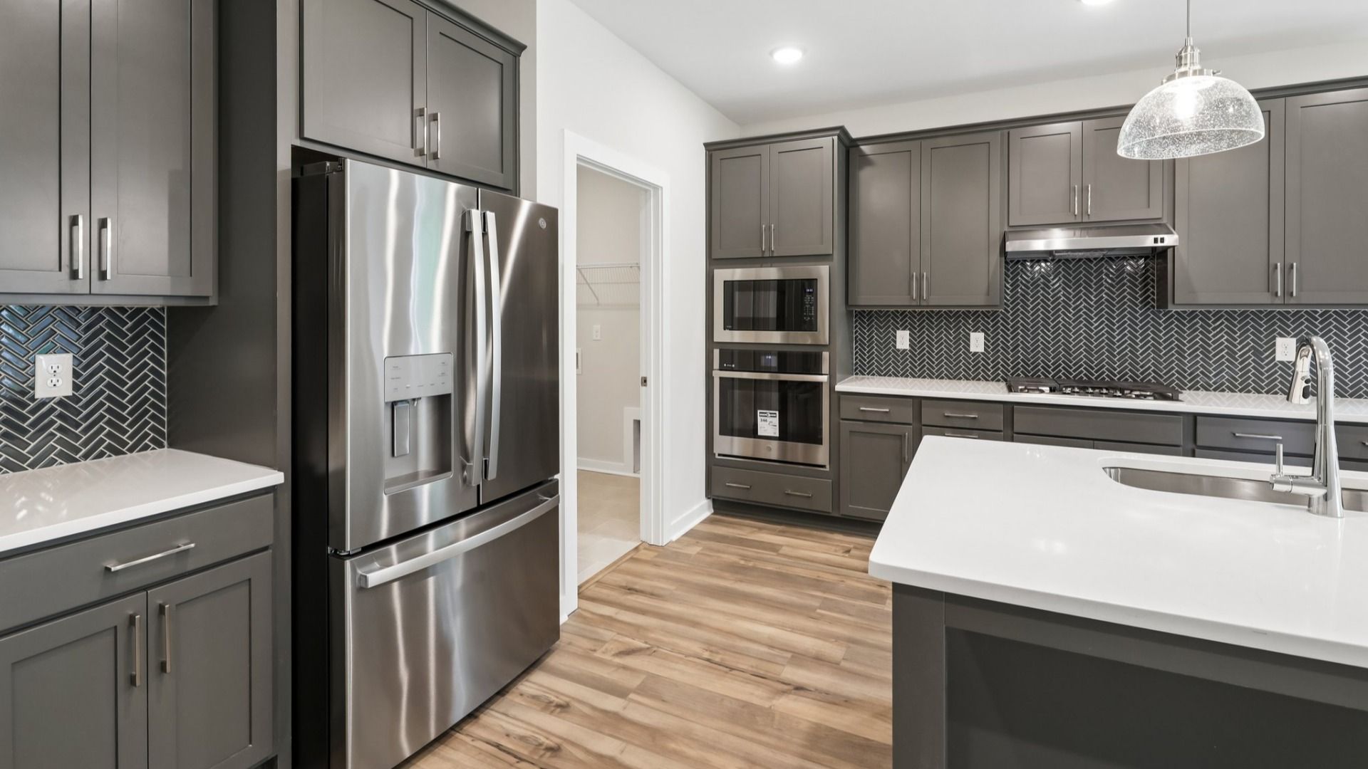 Kitchen with hard surface flooring, quartz countertops, and pendant lighting