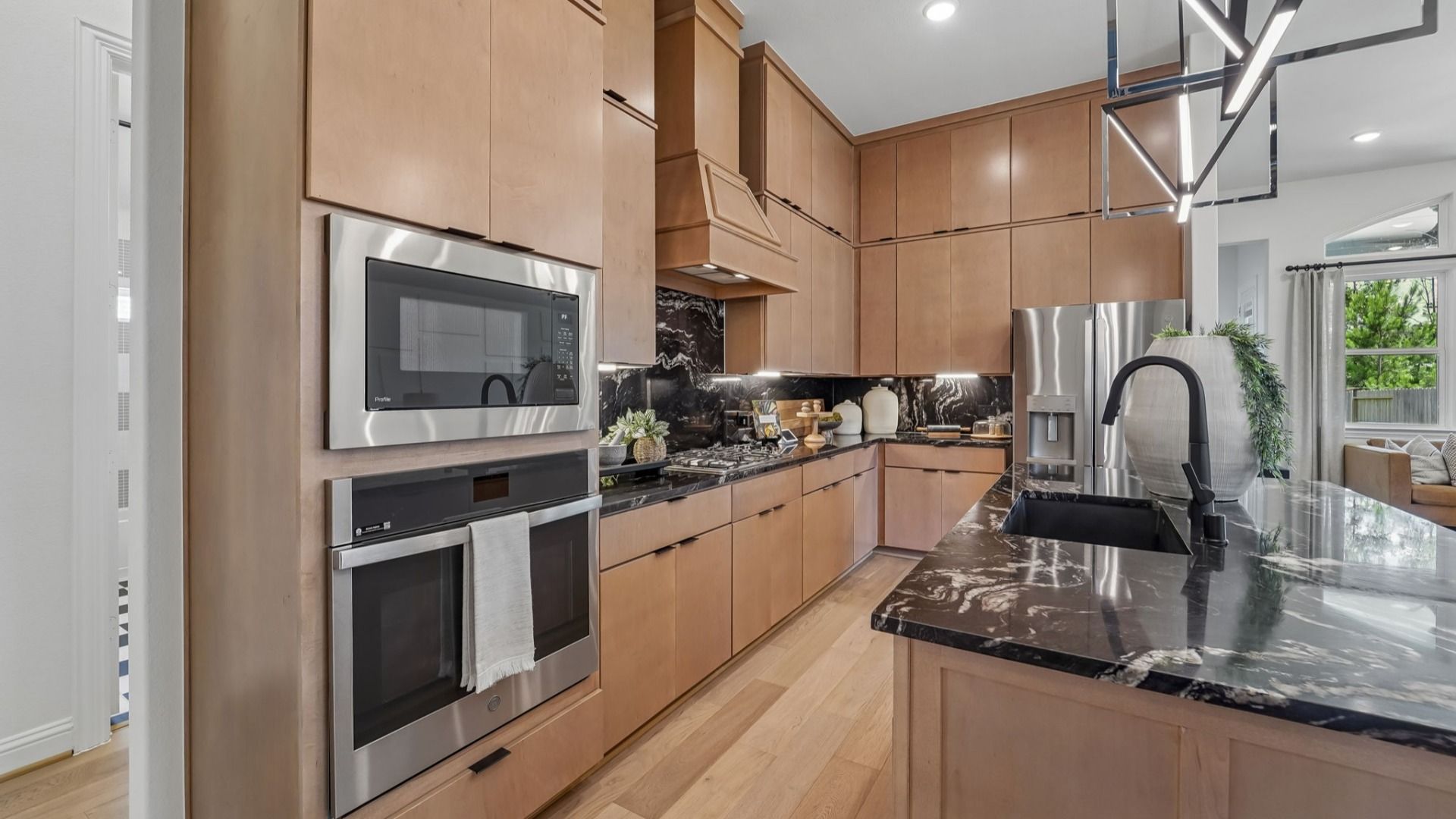 Experience this exquisite kitchen with sleek fixtures and natural light in The Woodlands Hills.