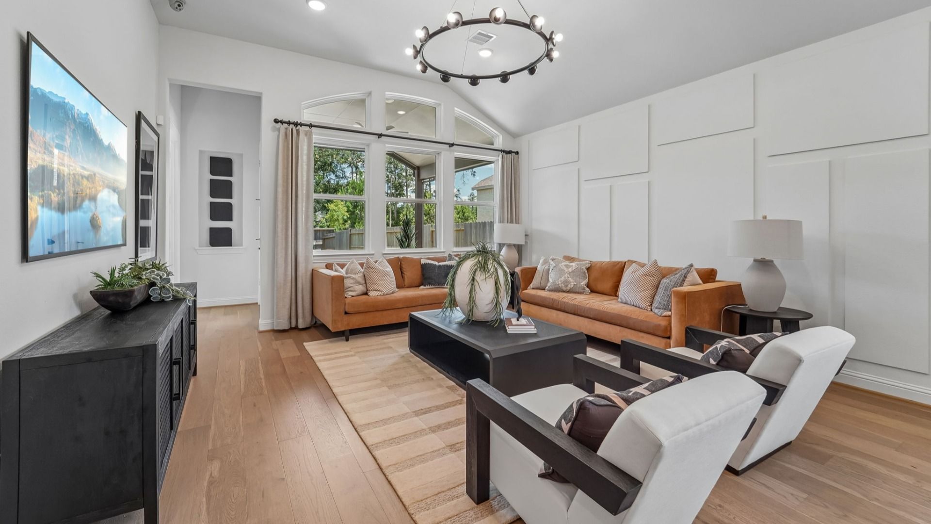 Experience luxury with vaulted ceilings and a chic chandelier, enhancing natural light in The Woodlands Hills.