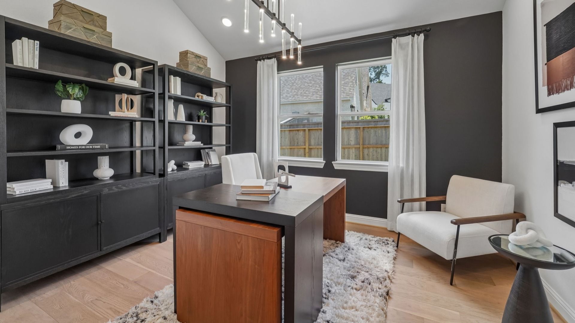 Experience sophistication with black shelves, sleek wood desk, and elegant decor in The Woodlands Hills.